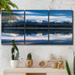 Three-panel canvas wall art featuring calm lake beneath mountains photograph, displayed in a boho-chic entryway above a console table.