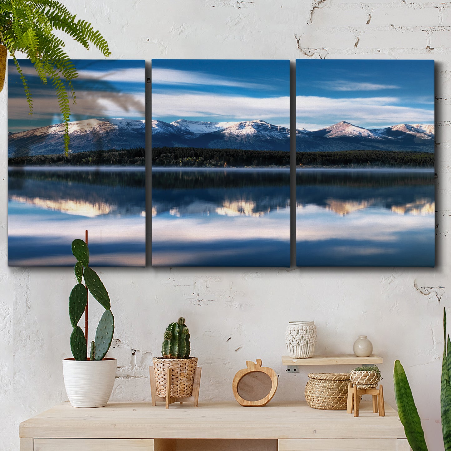 Three-panel canvas wall art featuring calm lake beneath mountains photograph, displayed in a boho-chic entryway above a console table.