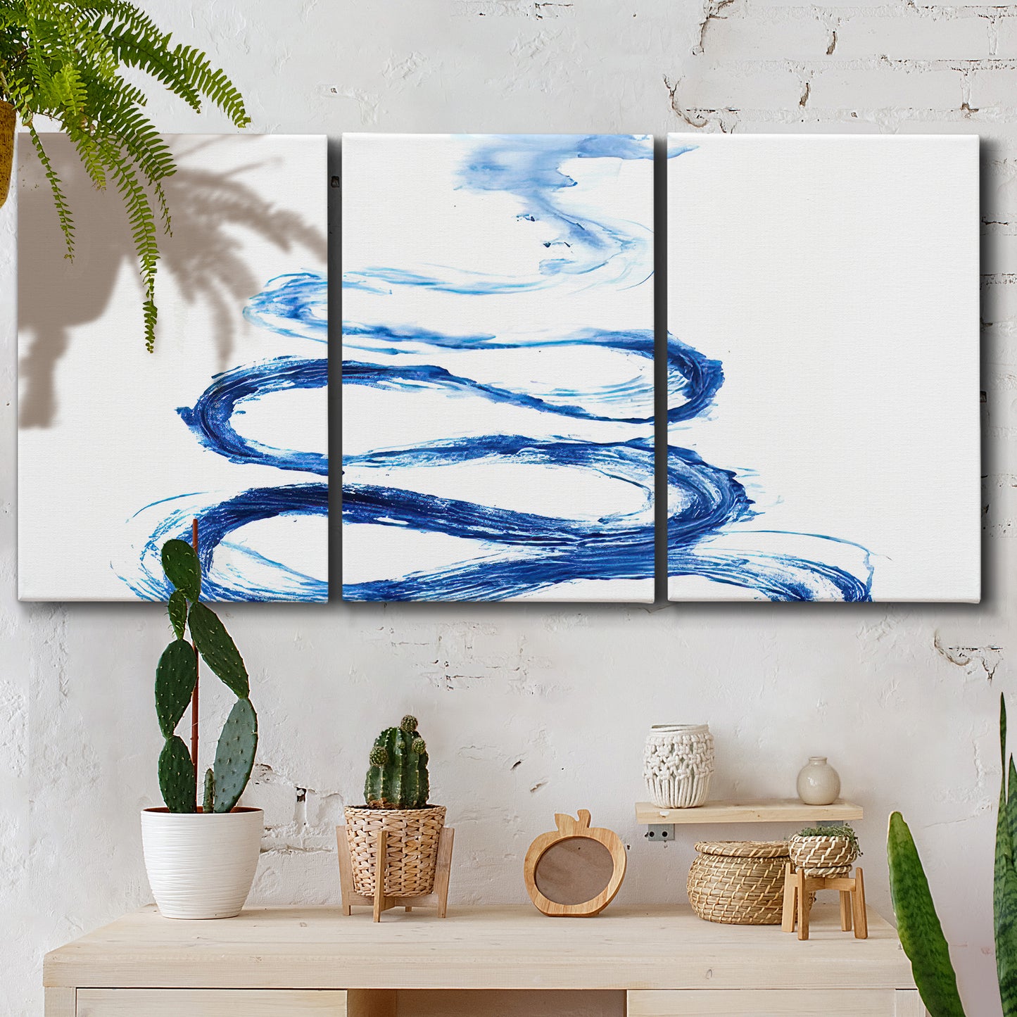 Three-panel canvas wall art featuring indigo abstract vapor watercolor, displayed in a boho-chic entryway above a console table.