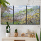 Three-panel canvas wall art featuring spring orchard in full bloom, displayed in a boho-chic entryway above a console table.