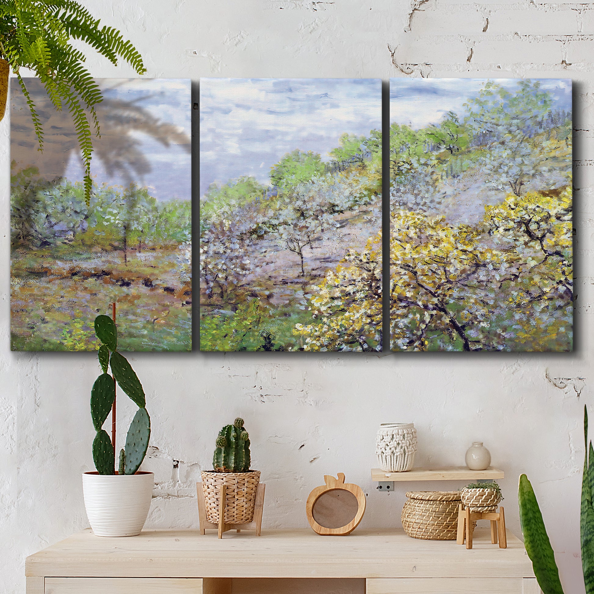 Three-panel canvas wall art featuring spring orchard in full bloom, displayed in a boho-chic entryway above a console table.