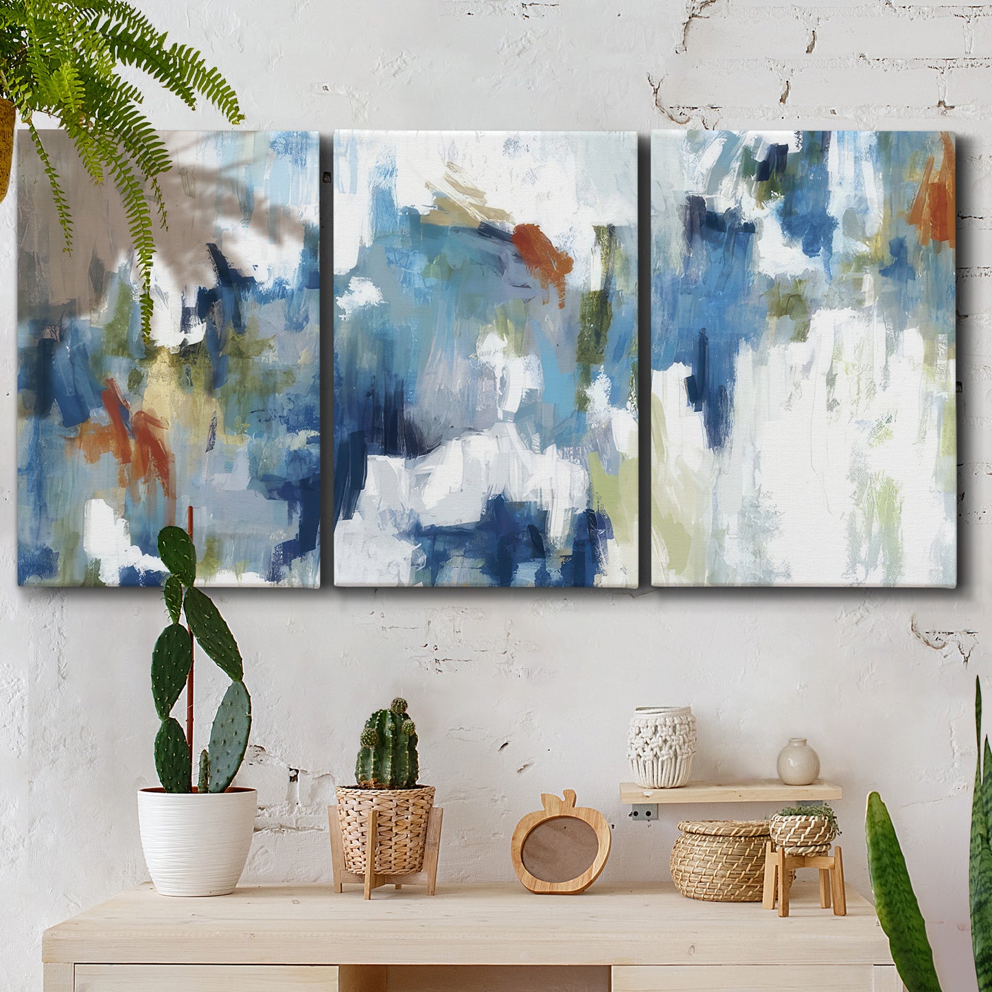 Three-panel canvas wall art featuring flowing abstract color movement, displayed in a boho-chic entryway above a console table.
