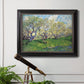 Impressionist spring orchard landscape by Vincent van Gogh in an ornate black frame with gilded inner detail displayed in a light-toned interior setting.