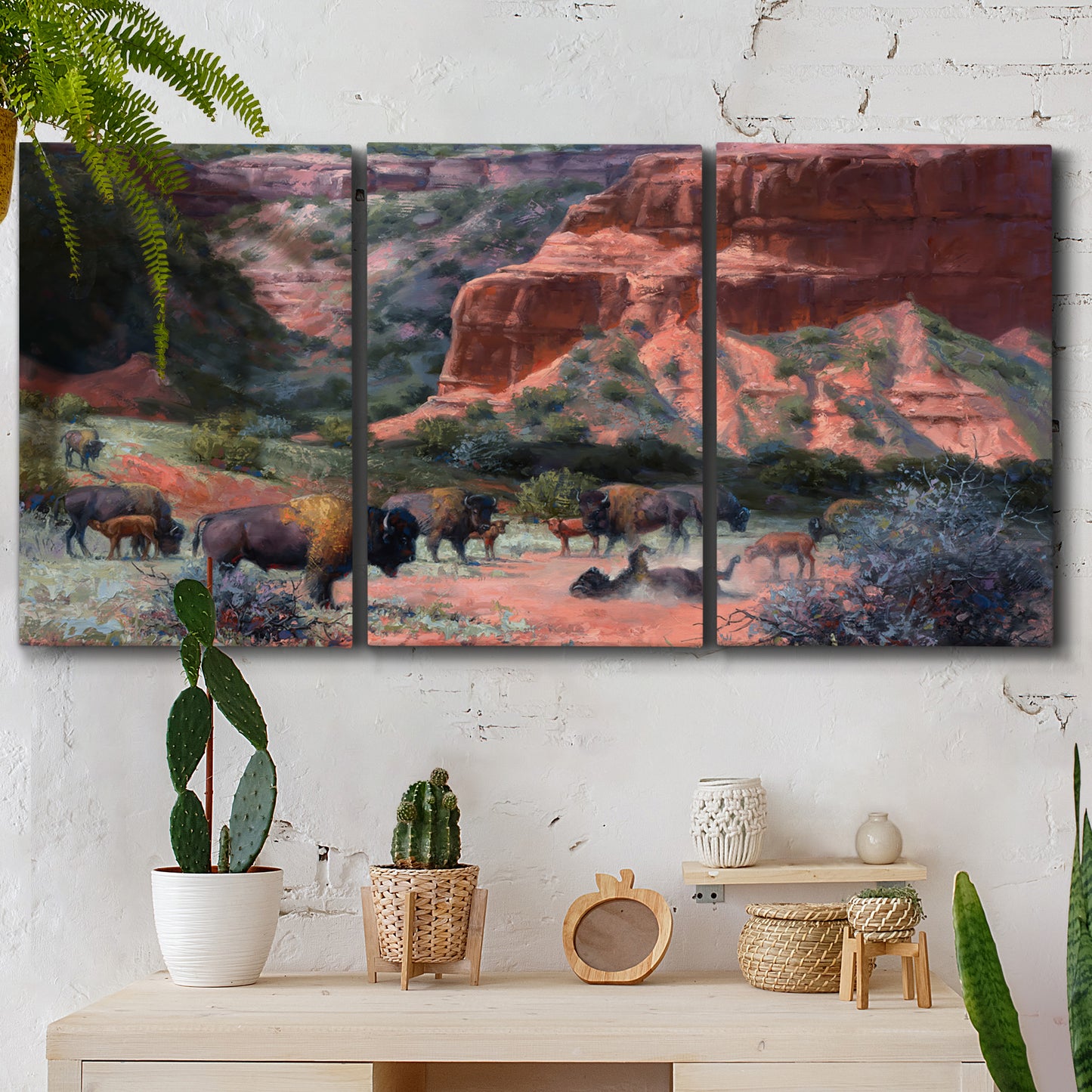 Three-panel canvas wall art featuring rugged canyon landscape with wildlife, displayed in a boho-chic entryway above a console table.