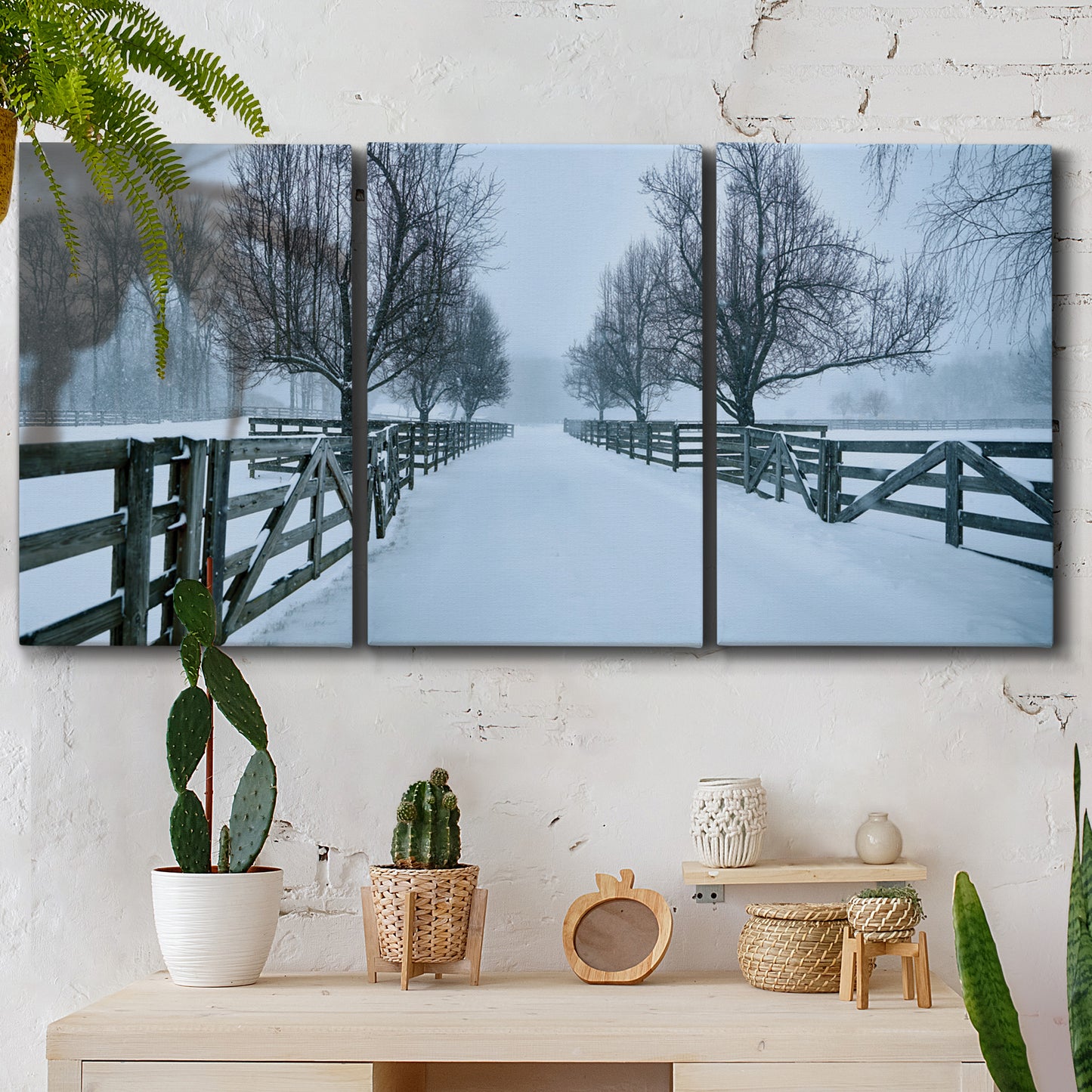 Three-panel canvas wall art featuring snow covered rural road photograph, displayed in a boho-chic entryway above a console table.