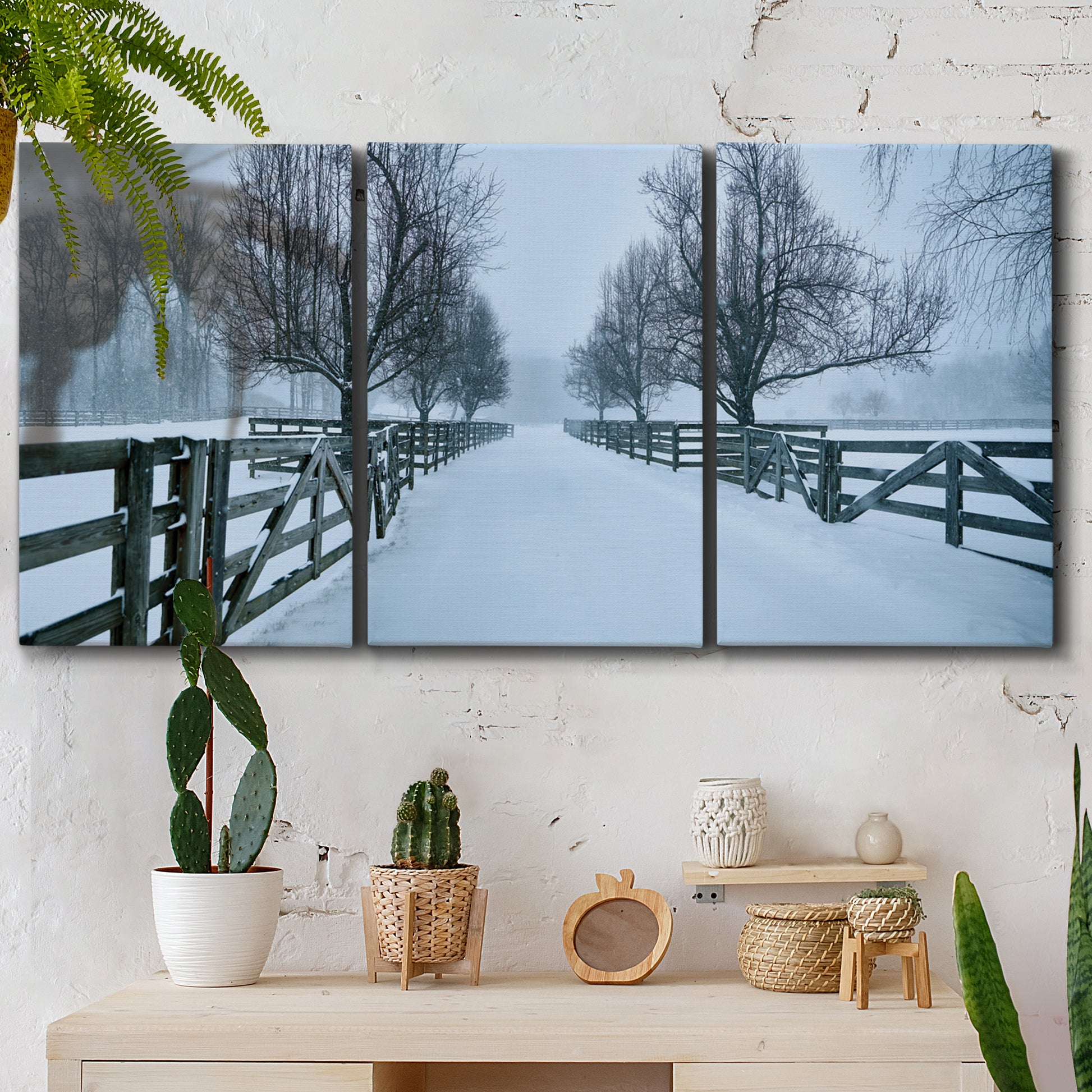 Three-panel canvas wall art featuring snow covered rural road photograph, displayed in a boho-chic entryway above a console table.