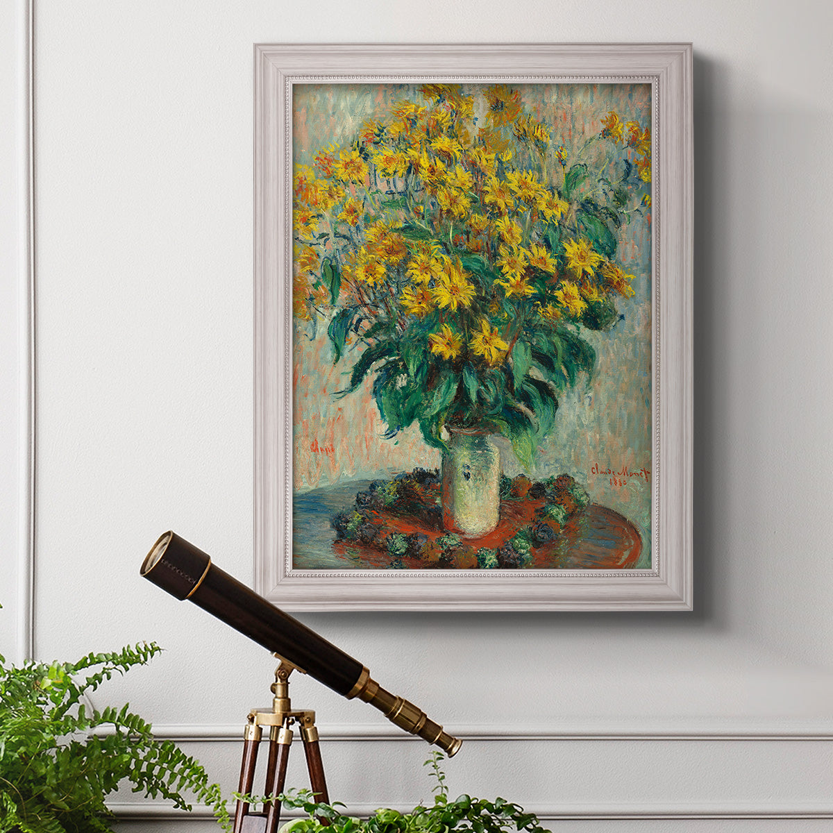 Impressionist floral painting of artichoke flowers by Claude Monet in an ornate weathered white frame displayed in a light-toned interior setting.
