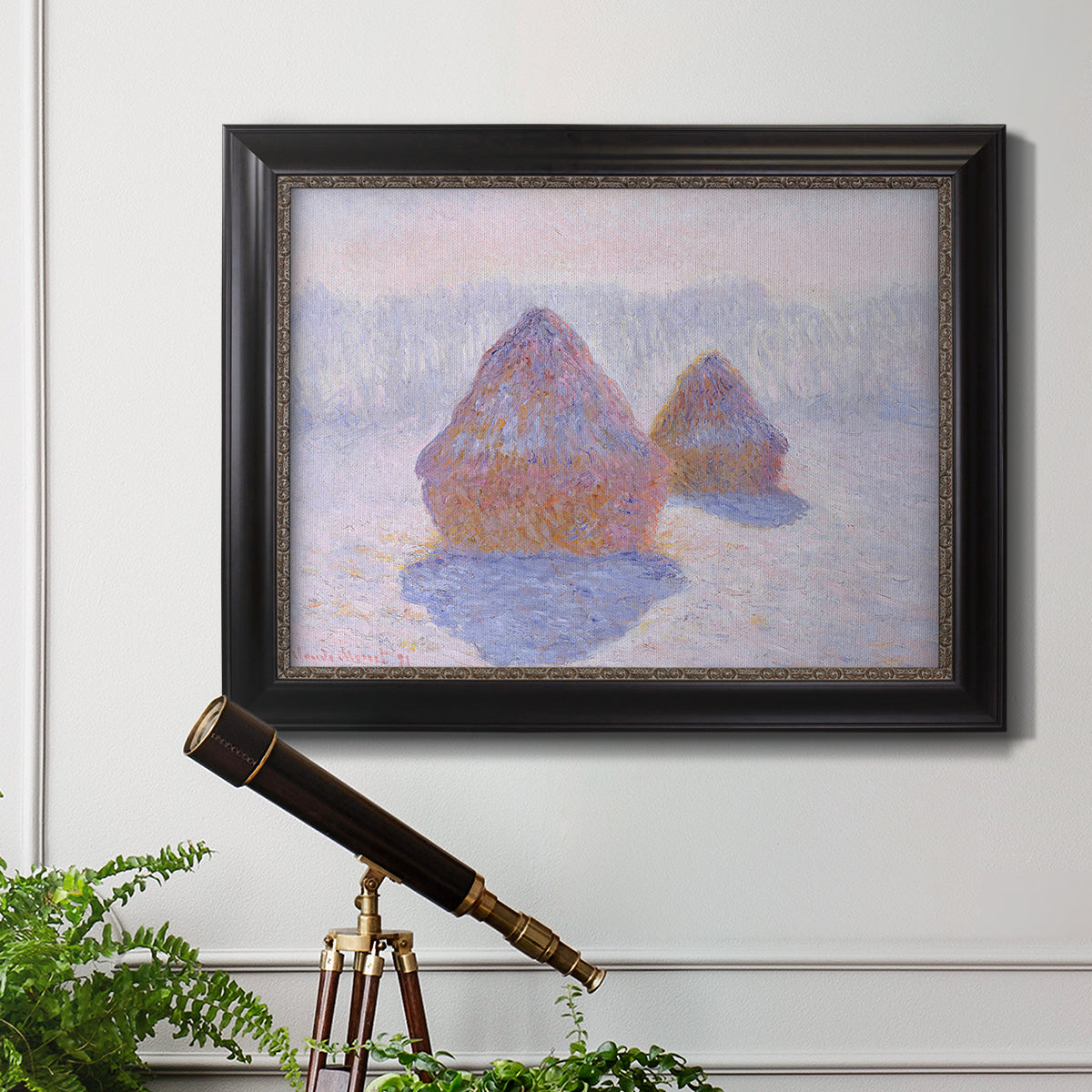 Impressionist winter haystack scene with sunlight by Claude Monet in an ornate black frame with gilded inner detail displayed in a light-toned interior setting.
