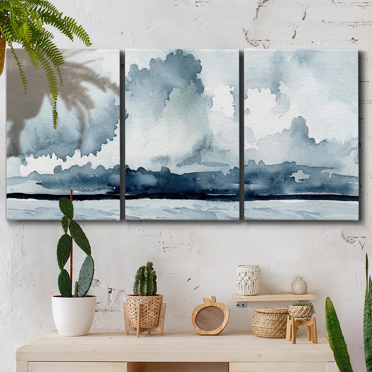 Three-panel canvas wall art featuring abstract rainstorm watercolor, displayed in a boho-chic entryway above a console table.