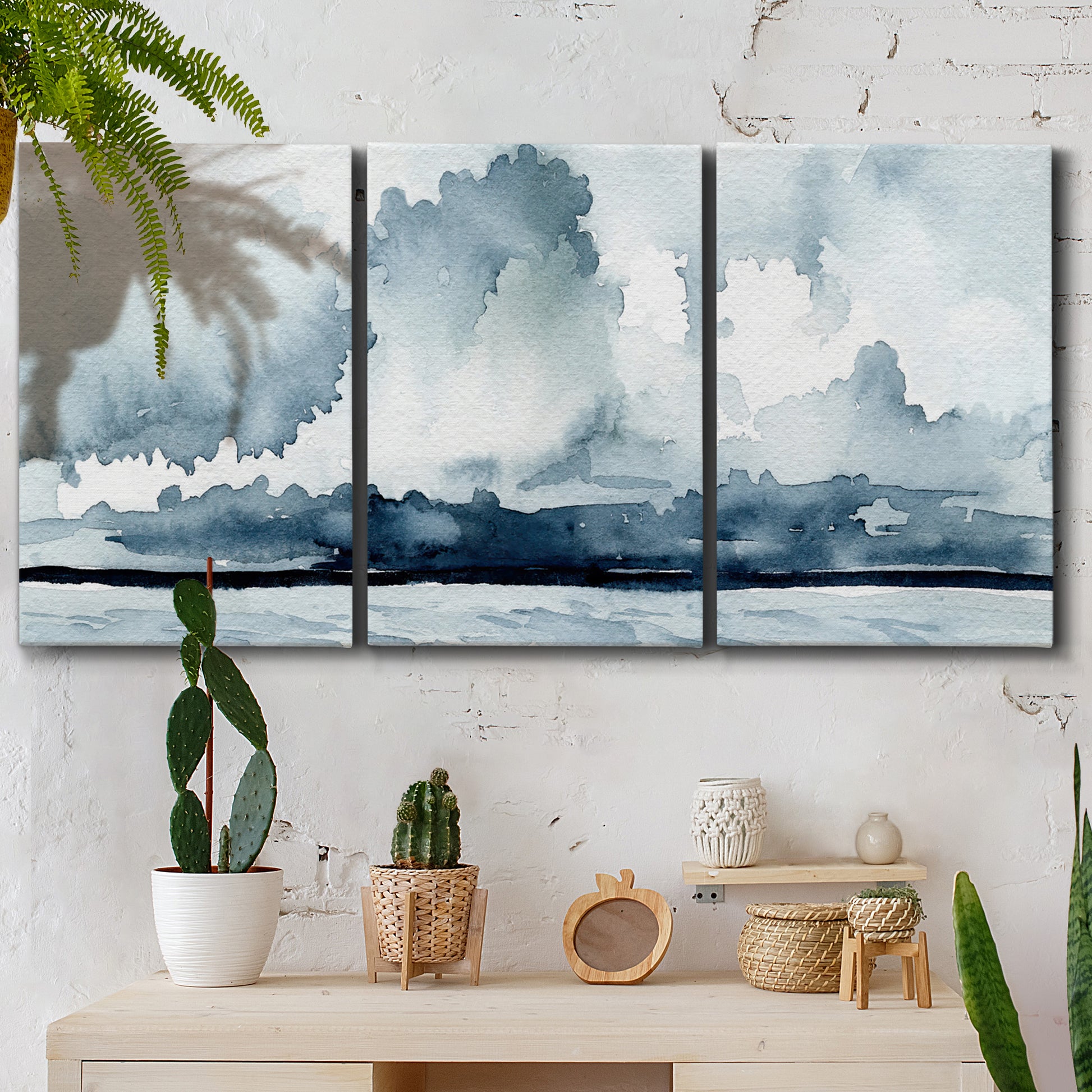 Three-panel canvas wall art featuring abstract rainstorm watercolor, displayed in a boho-chic entryway above a console table.