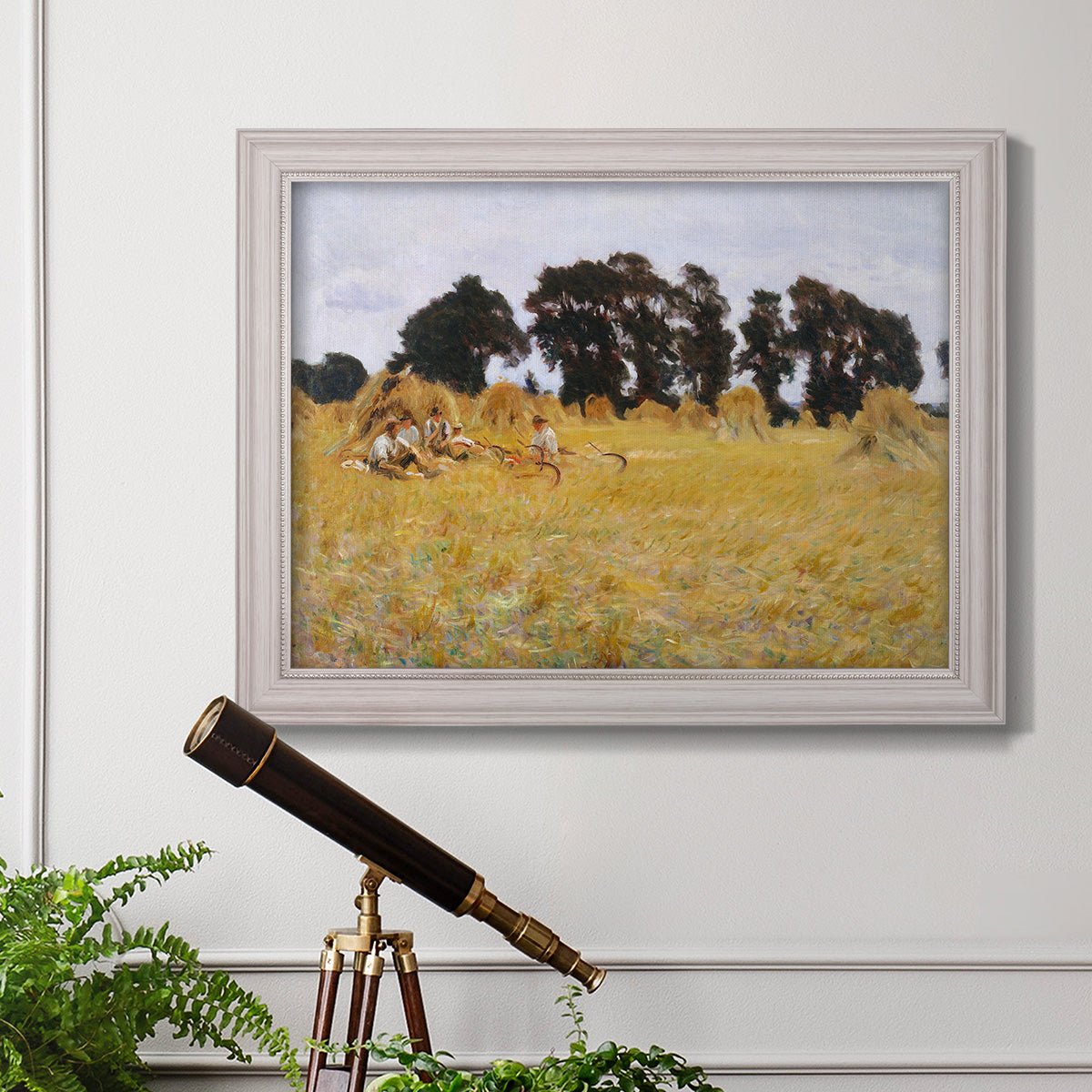 Impressionist rural harvest scene by John Singer Sargent in an ornate weathered white frame displayed in a light-toned interior setting.