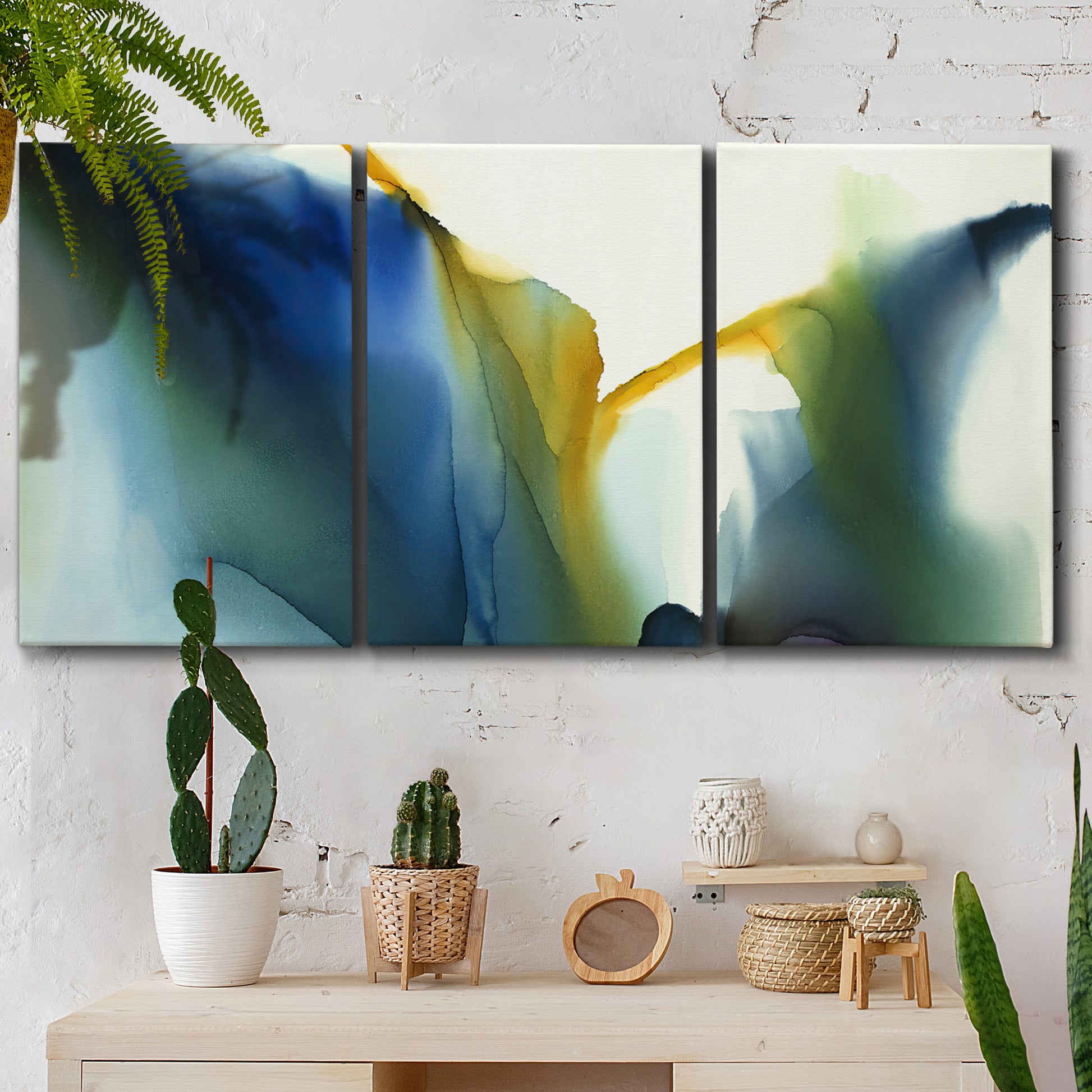 Three-panel canvas wall art featuring soft abstract mask like forms, displayed in a boho-chic entryway above a console table.