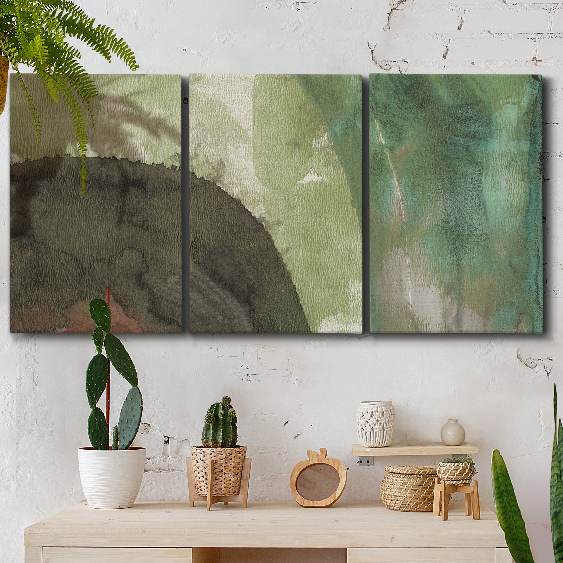 Three-panel canvas wall art featuring layered green abstract composition, displayed in a boho-chic entryway above a console table.