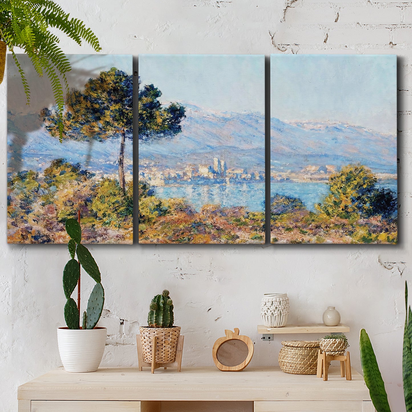 Three-panel canvas wall art featuring coastal town viewed from hillside, displayed in a boho-chic entryway above a console table.