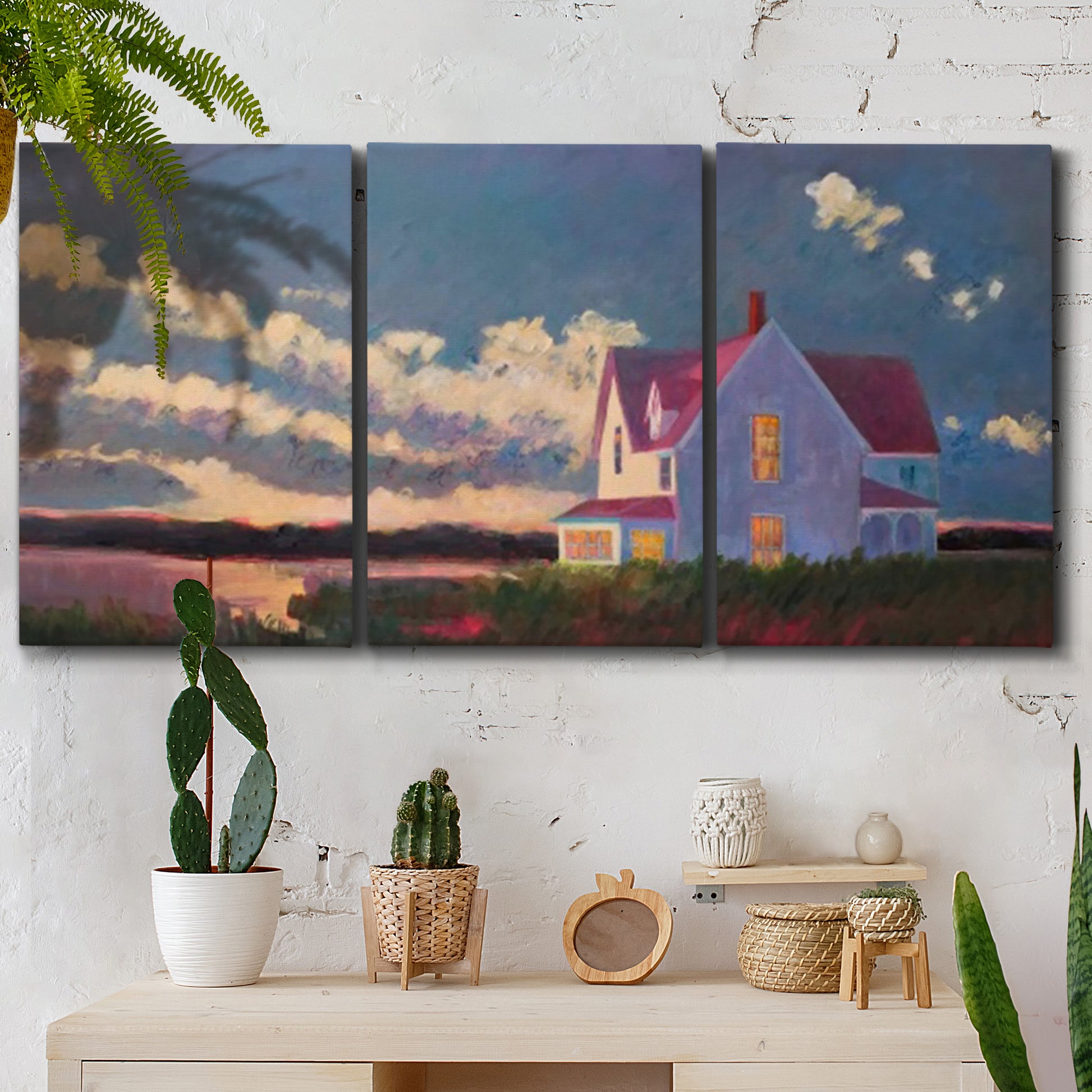 Three-panel canvas wall art featuring farmhouse scene before approaching storm, displayed in a boho-chic entryway above a console table.