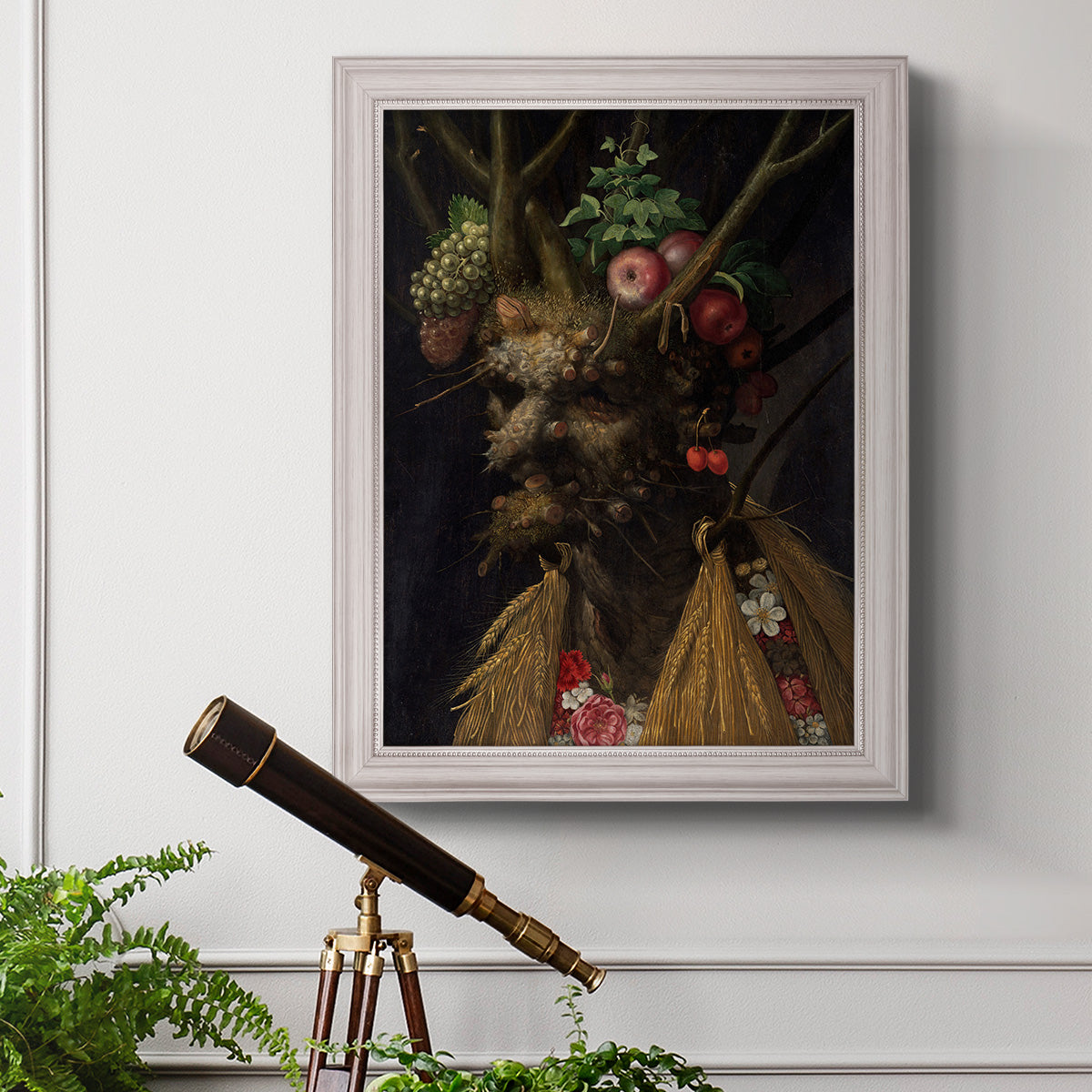 Surreal allegorical portrait representing the four seasons by Giuseppe Arcimboldo in an ornate weathered white frame displayed in a light-toned interior setting.