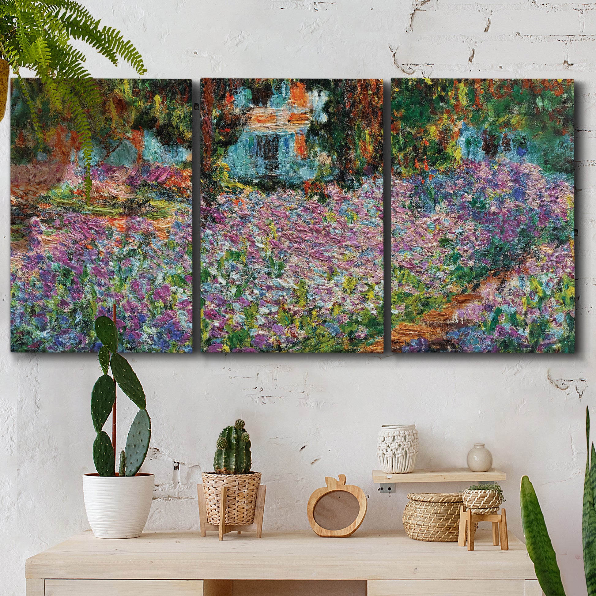 Three-panel canvas wall art featuring blooming irises in garden bed, displayed in a boho-chic entryway above a console table.