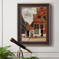 Realist city street scene by Johannes Vermeer in an ornate bronzed mahogany wood frame displayed in a light-toned interior setting.