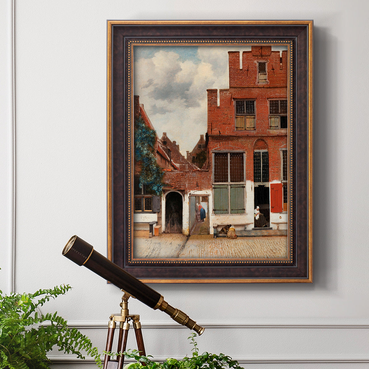 Realist city street scene by Johannes Vermeer in an ornate bronzed mahogany wood frame displayed in a light-toned interior setting.