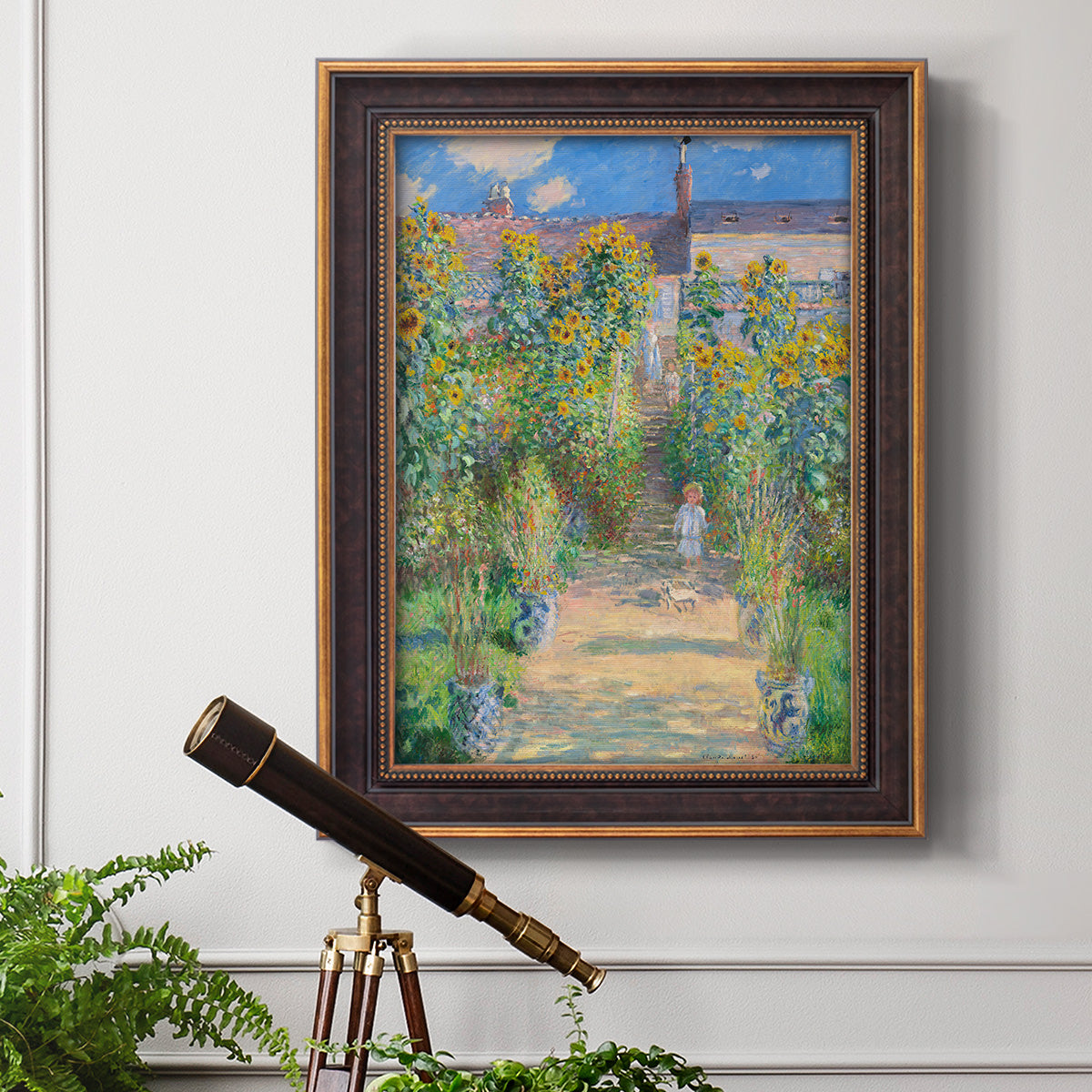 Impressionist garden landscape painting by Claude Monet in an ornate bronzed mahogany wood frame displayed in a light-toned interior setting.