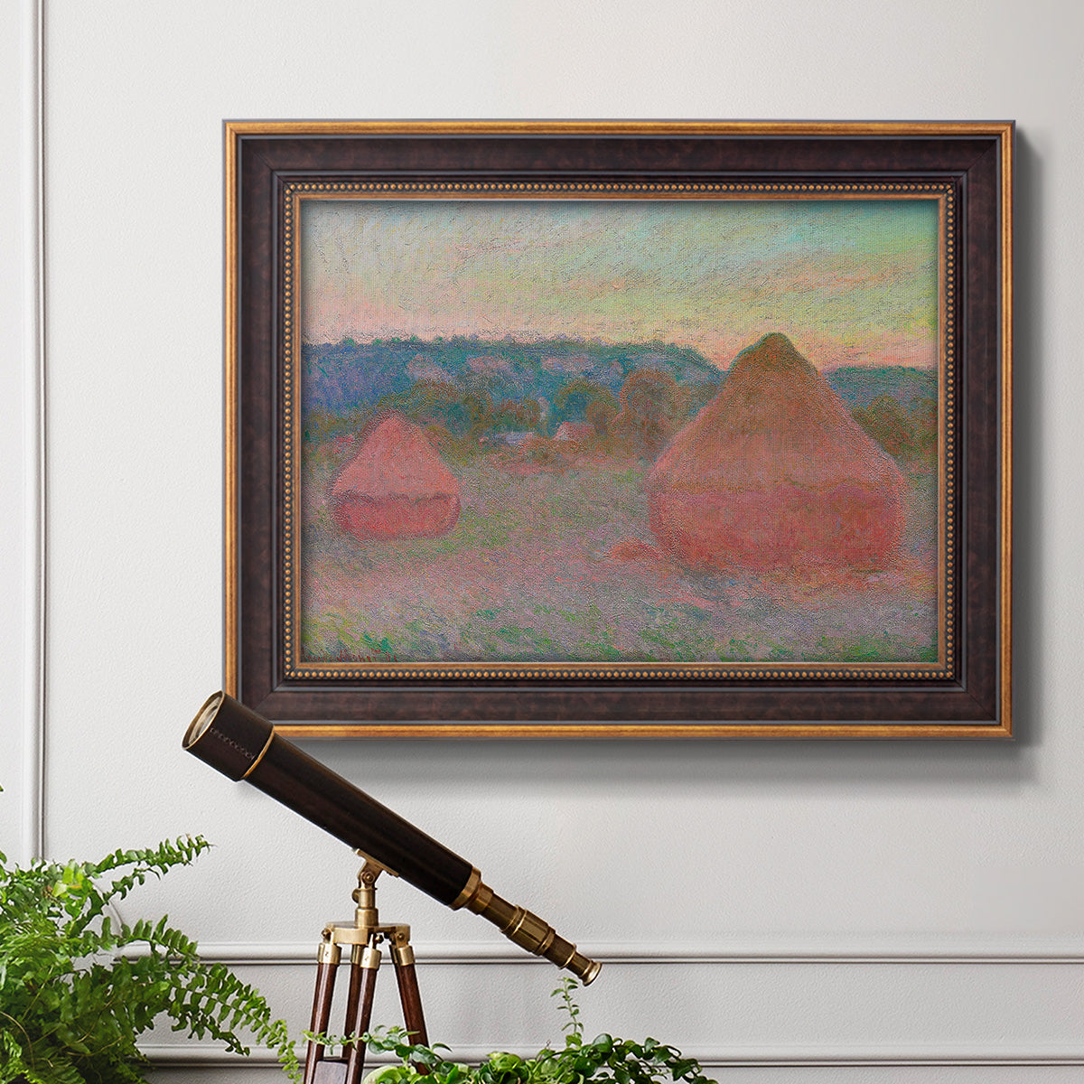 Impressionist haystack series landscape by Claude Monet in an ornate bronzed mahogany wood frame displayed in a light-toned interior setting.