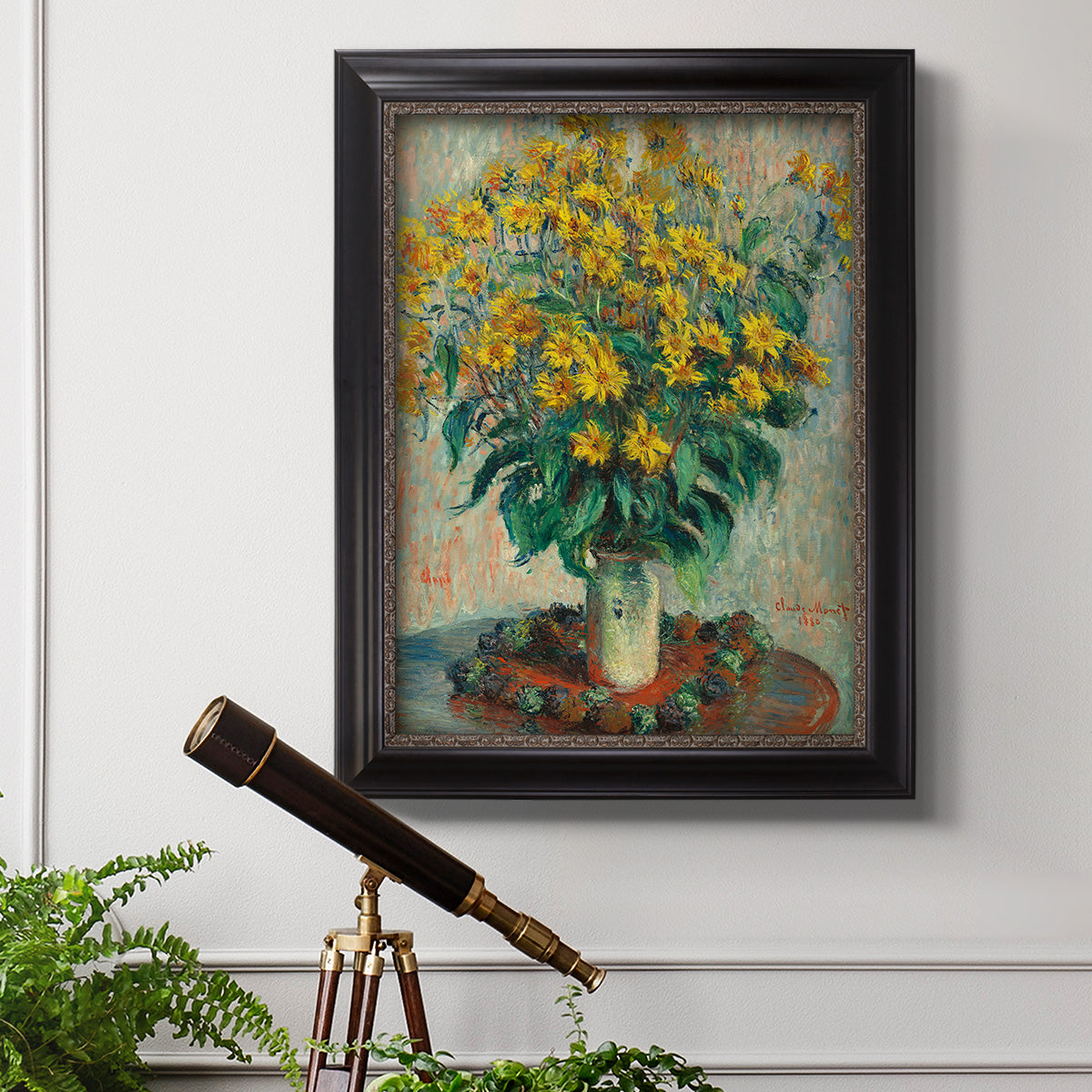 Impressionist floral painting of artichoke flowers by Claude Monet in an ornate black frame with gilded inner detail displayed in a light-toned interior setting.