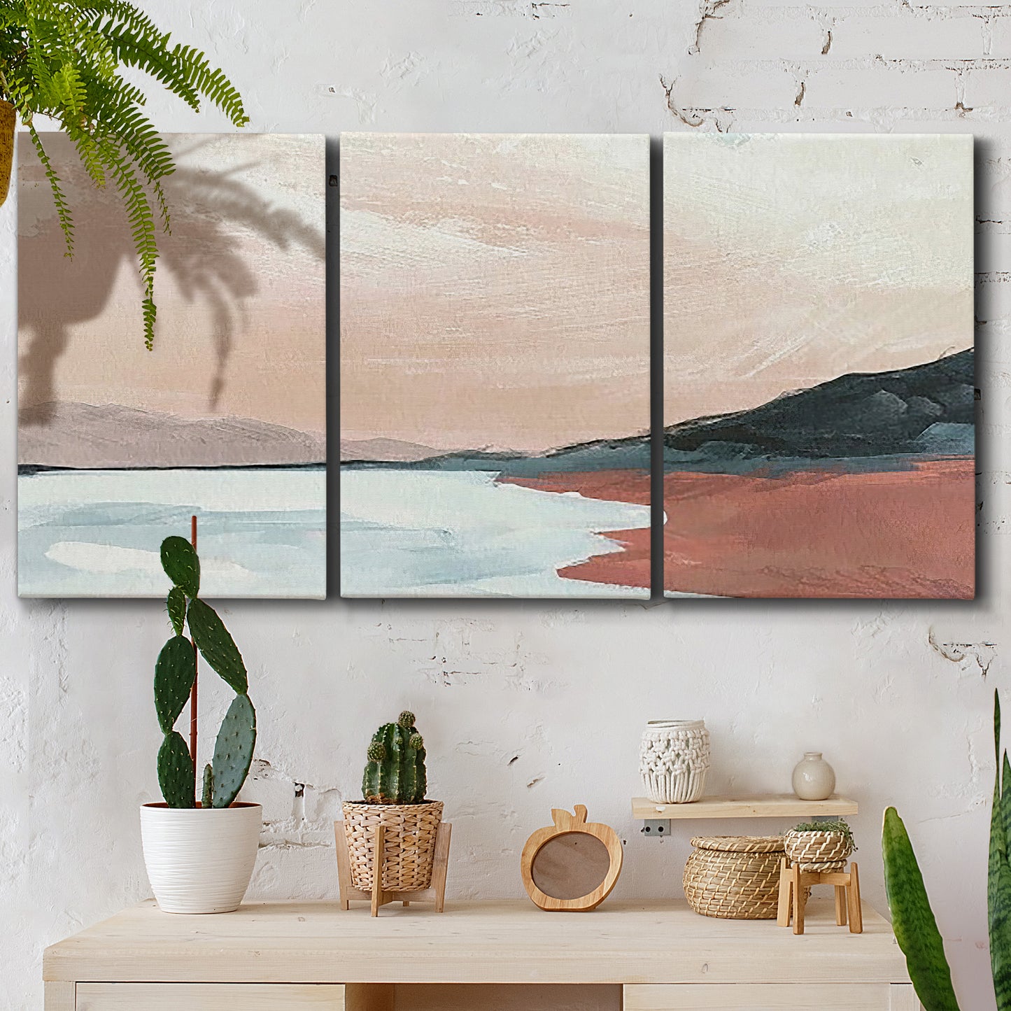 Three-panel canvas wall art featuring quiet coastline with distant horizon, displayed in a boho-chic entryway above a console table.
