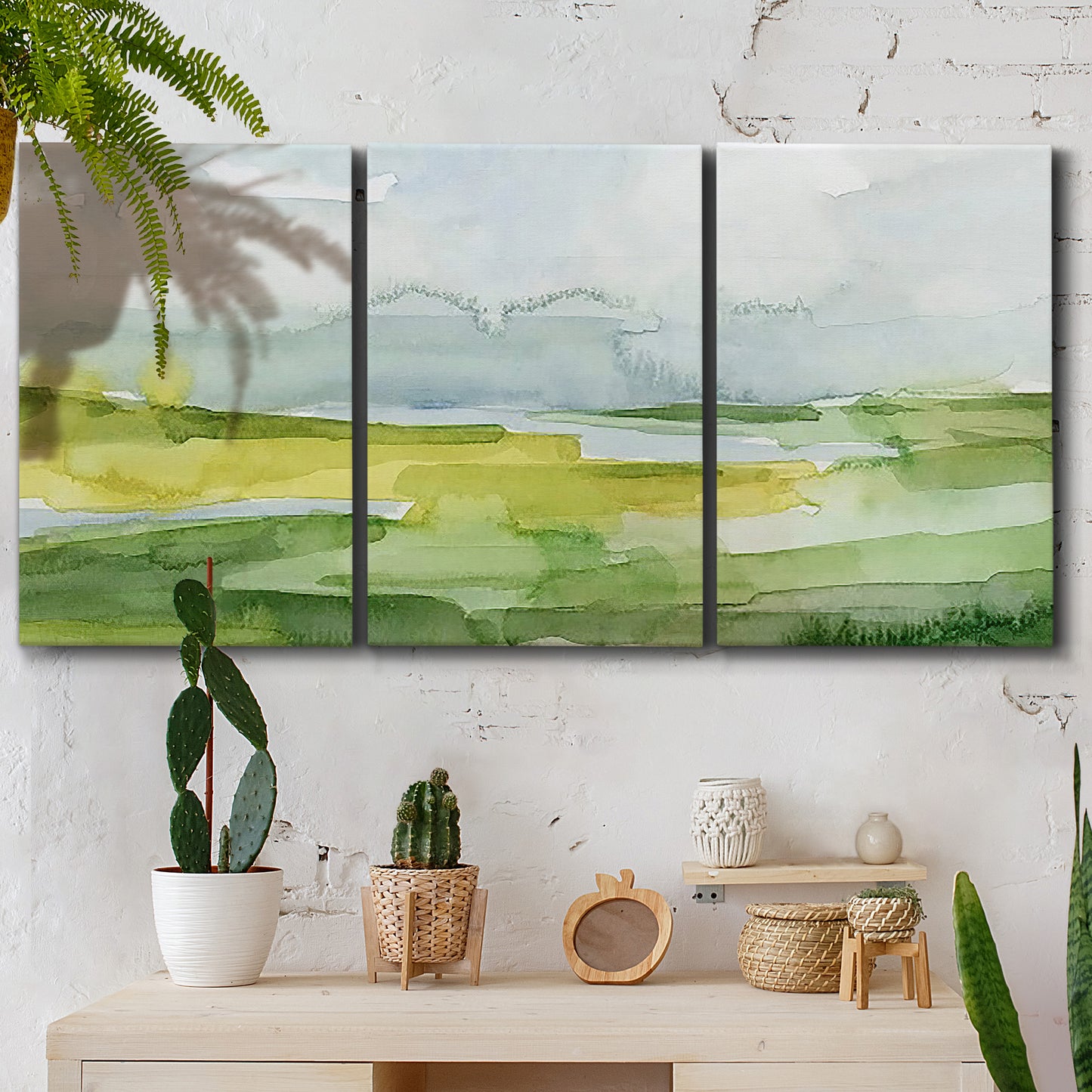 Three-panel canvas wall art featuring lowland wetlands with reflective water, displayed in a boho-chic entryway above a console table.