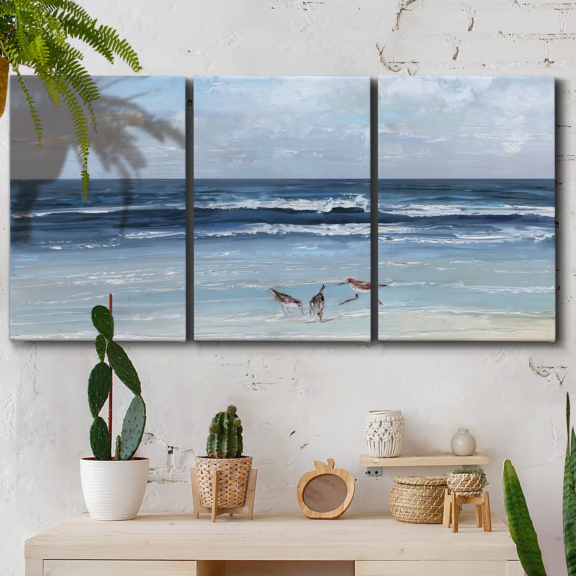 Three-panel canvas wall art featuring loose farmhouse style floral painting, displayed in a boho-chic entryway above a console table.