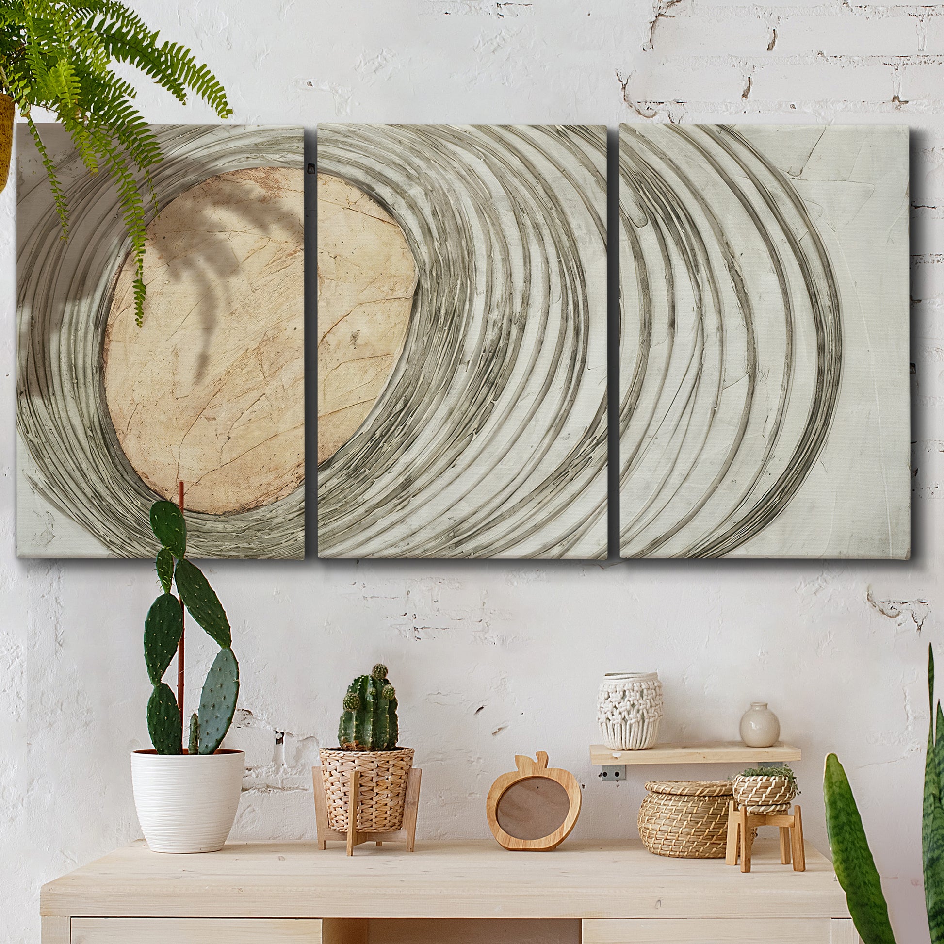 Three-panel canvas wall art featuring circular abstract energy forms, displayed in a boho-chic entryway above a console table.