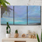 Three-panel canvas wall art featuring coastal shoreline with gentle surf, displayed in a boho-chic entryway above a console table.