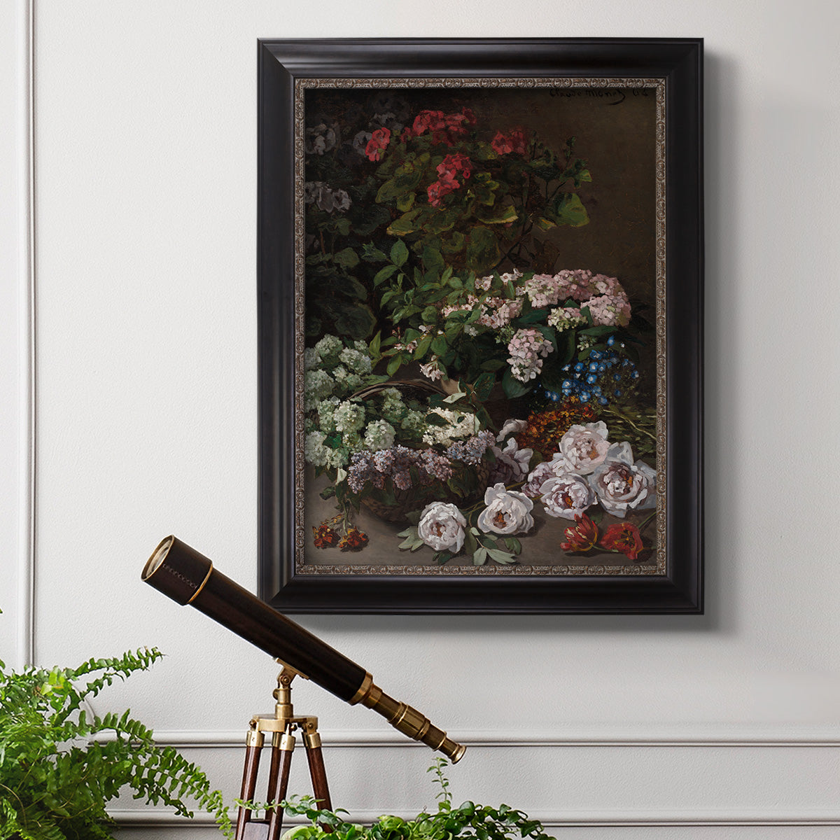 Early impressionist floral painting by Claude Monet in an ornate black frame with gilded inner detail displayed in a light-toned interior setting.
