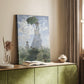 Canvas art print of a figure holding a parasol against a bright sky and soft grass styled in a home decor setting.
