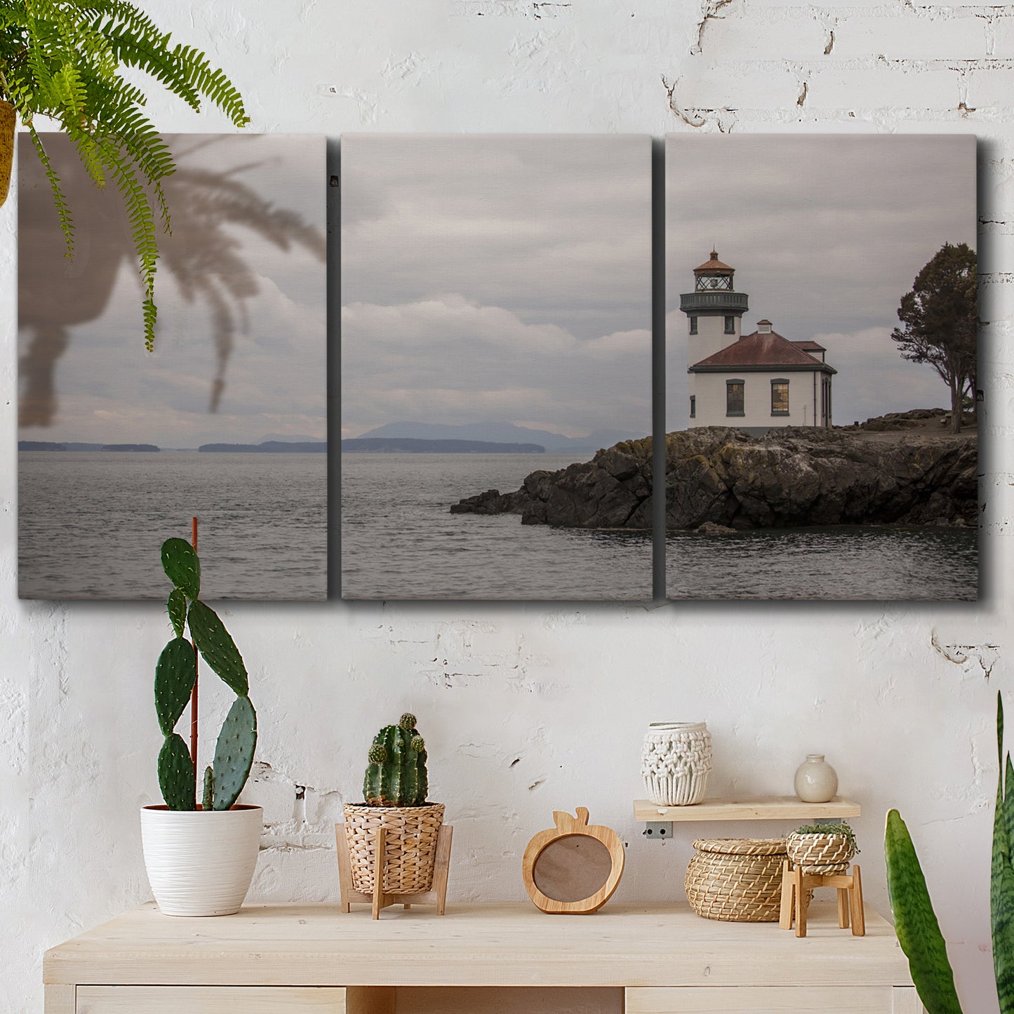 Three-panel canvas wall art featuring lighthouse watching over coastline, displayed in a boho-chic entryway above a console table.