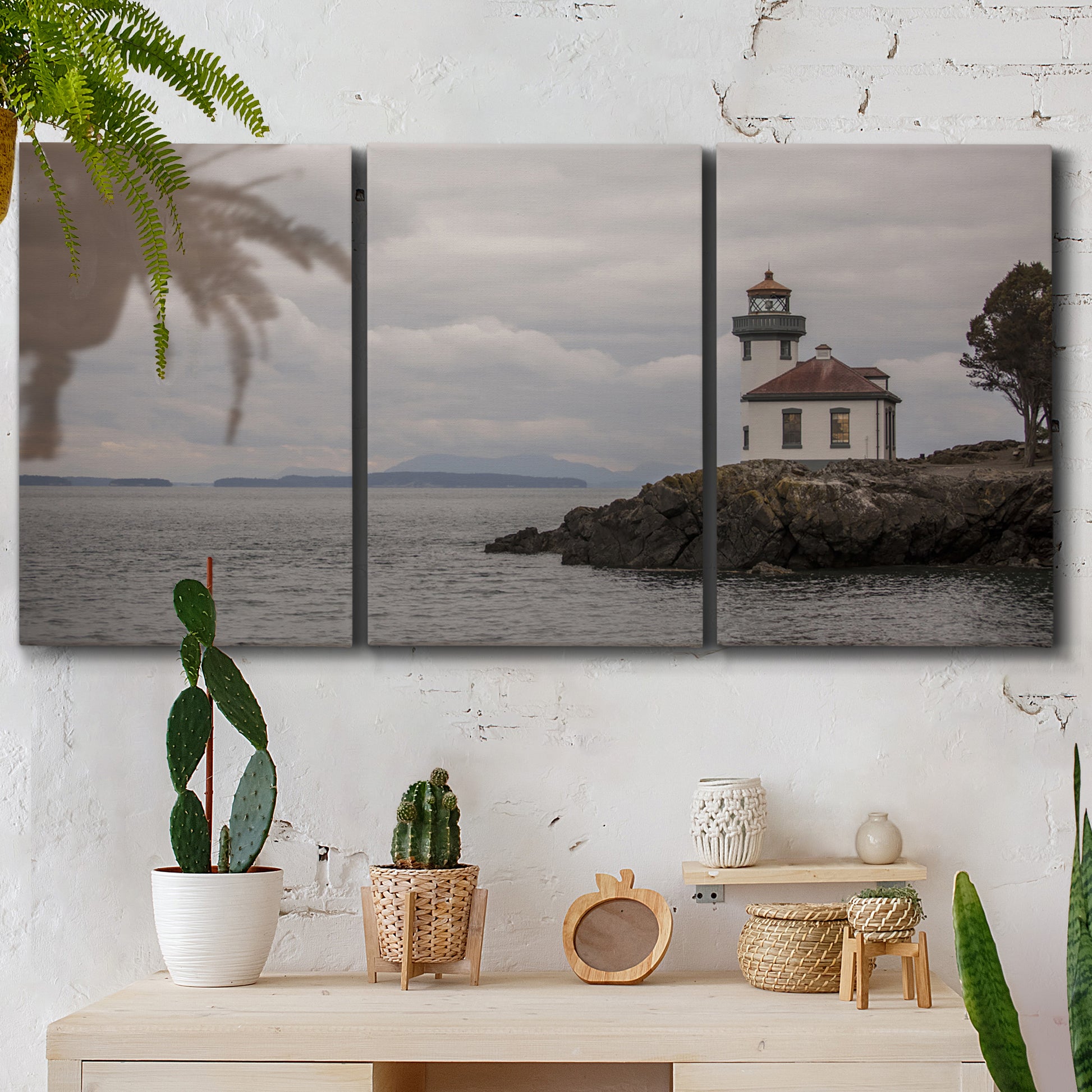 Three-panel canvas wall art featuring lighthouse watching over coastline, displayed in a boho-chic entryway above a console table.