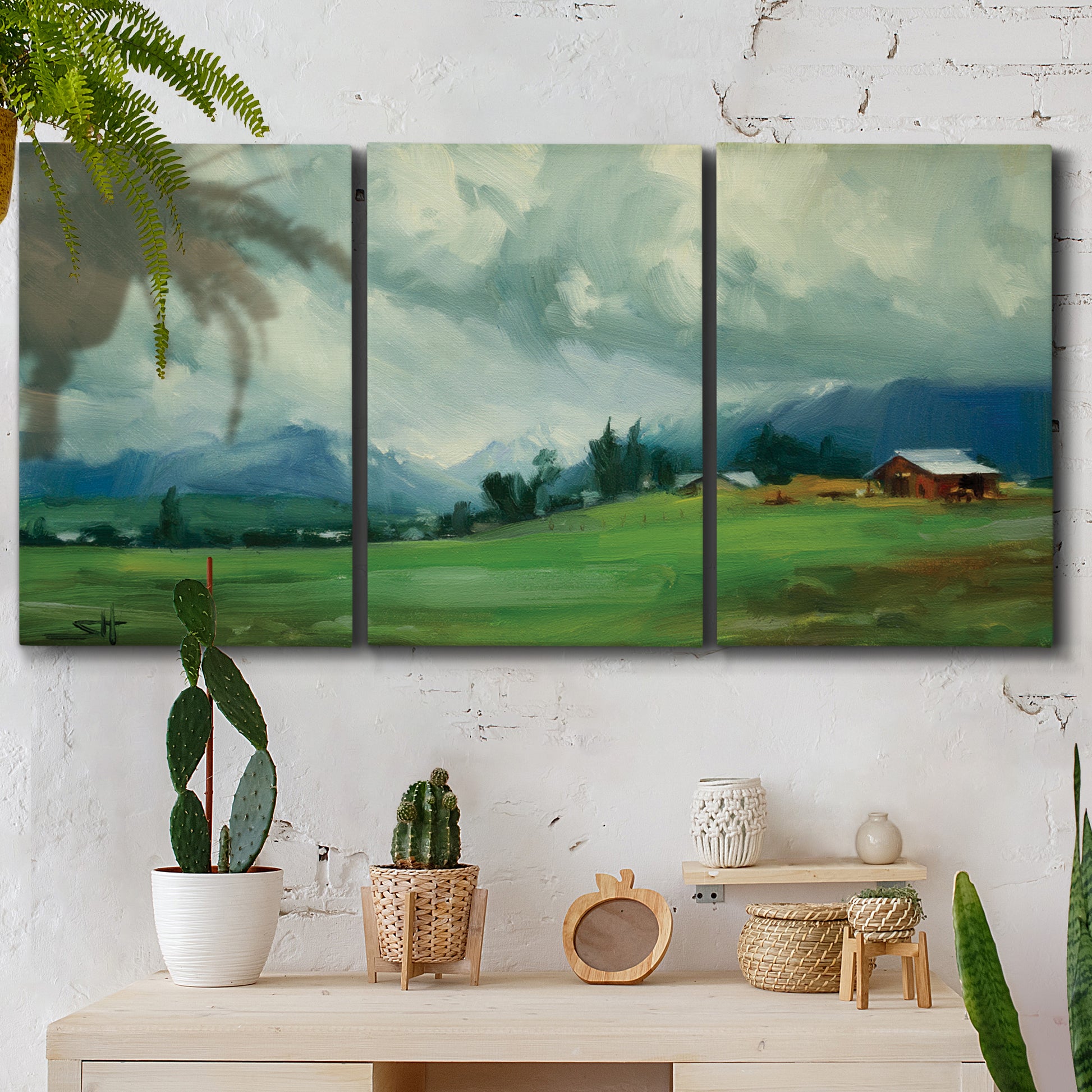 Three-panel canvas wall art featuring wide pastoral valley landscape, displayed in a boho-chic entryway above a console table.