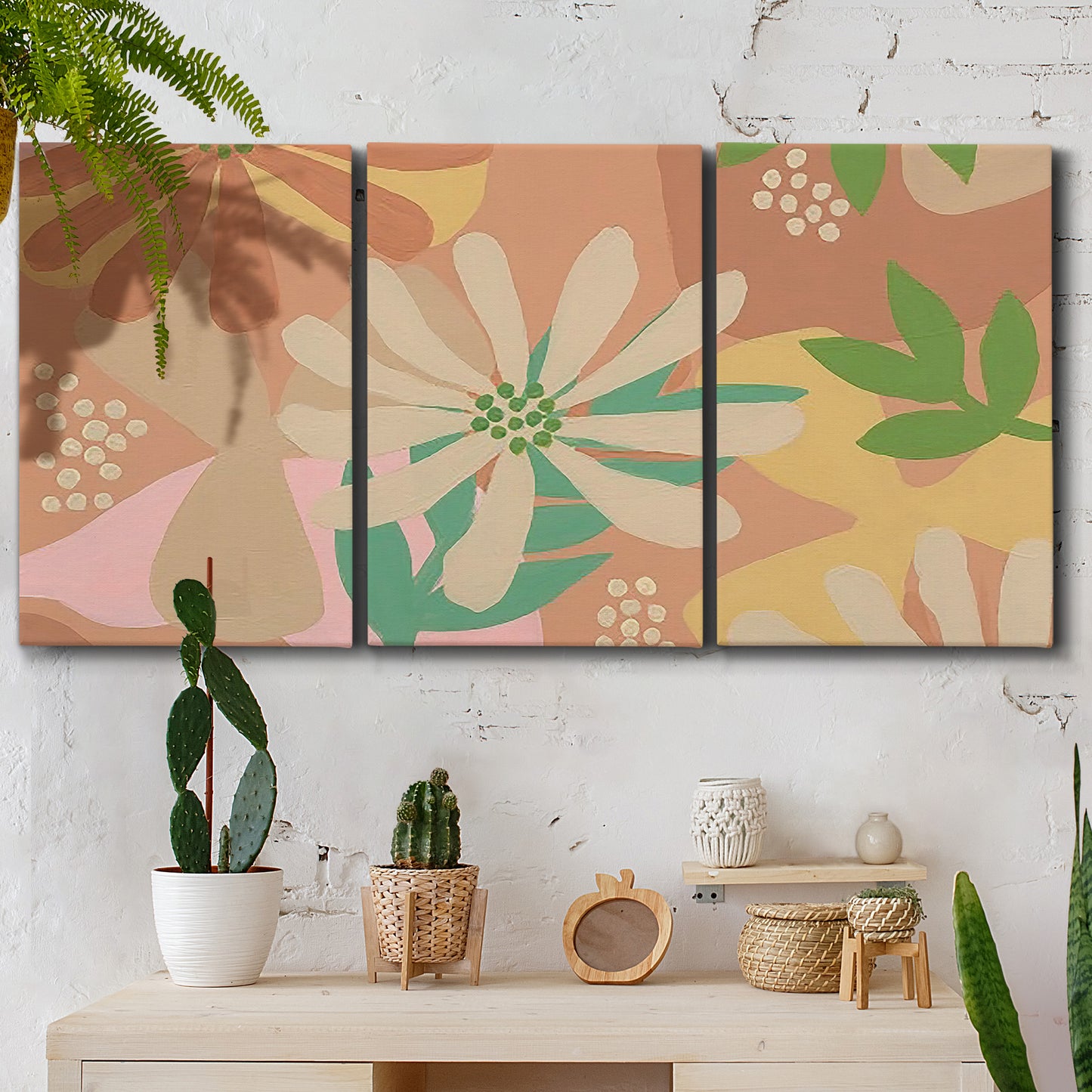 Three-panel canvas wall art featuring neutral toned botanical floral silhouettes, displayed in a boho-chic entryway above a console table.