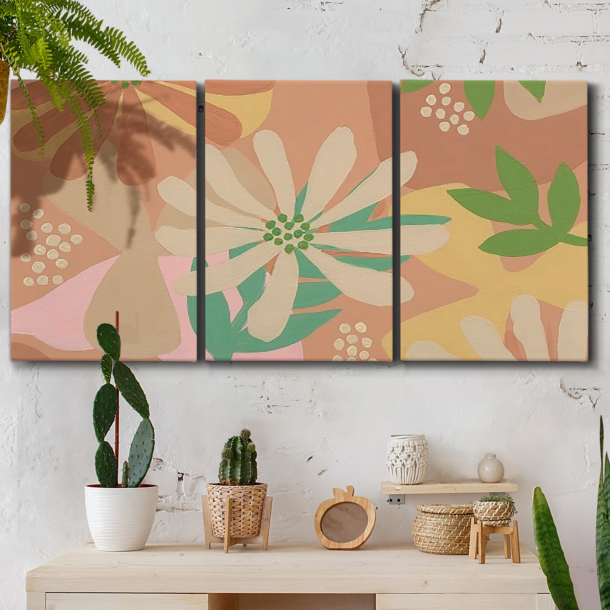 Three-panel canvas wall art featuring neutral toned botanical floral silhouettes, displayed in a boho-chic entryway above a console table.