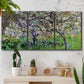 Three-panel canvas wall art featuring apple trees blooming beside water, displayed in a boho-chic entryway above a console table.