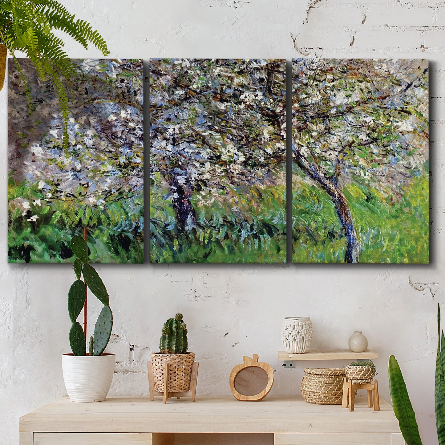 Three-panel canvas wall art featuring apple trees blooming beside water, displayed in a boho-chic entryway above a console table.