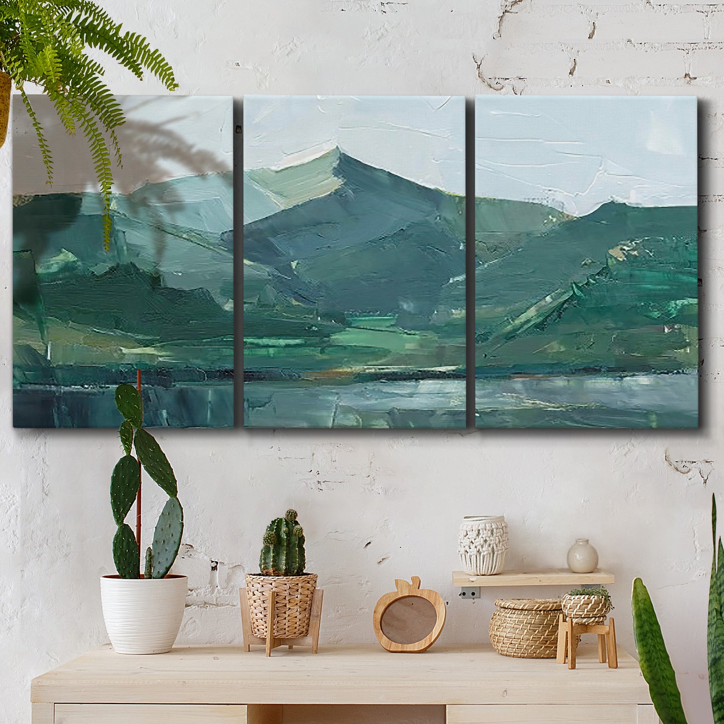 Three-panel canvas wall art featuring muted mountain range in grey tones, displayed in a boho-chic entryway above a console table.