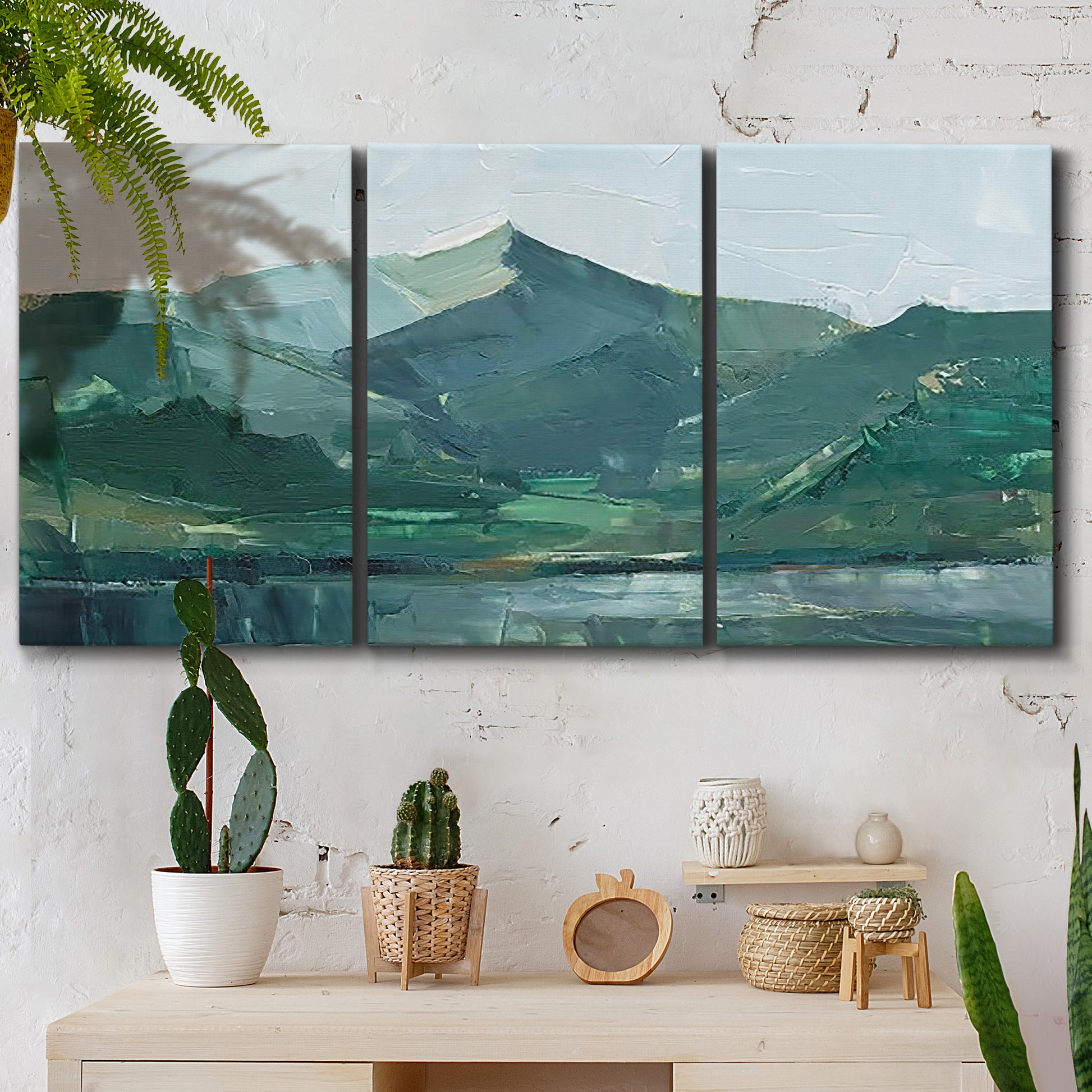 Three-panel canvas wall art featuring muted mountain range in grey tones, displayed in a boho-chic entryway above a console table.