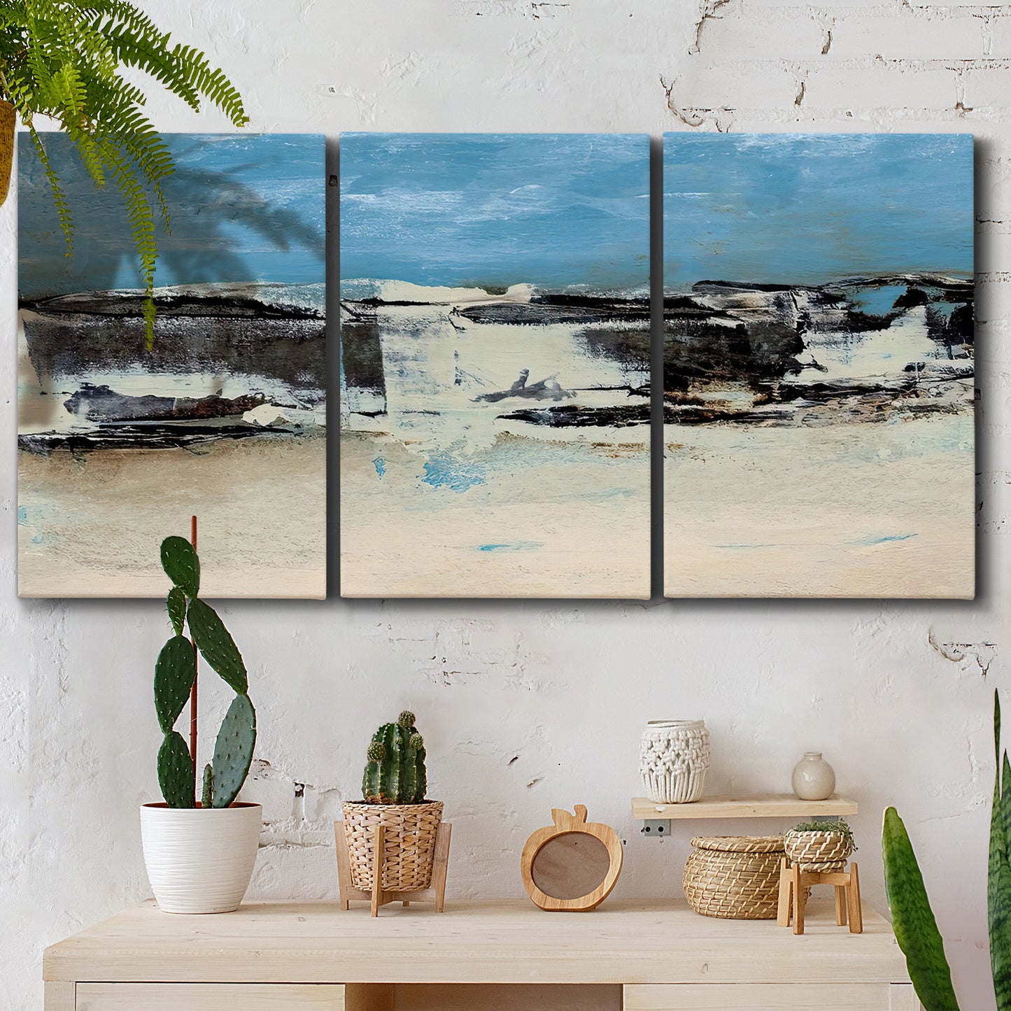 Three-panel canvas wall art featuring abstract bridge landscape in cyan, displayed in a boho-chic entryway above a console table.