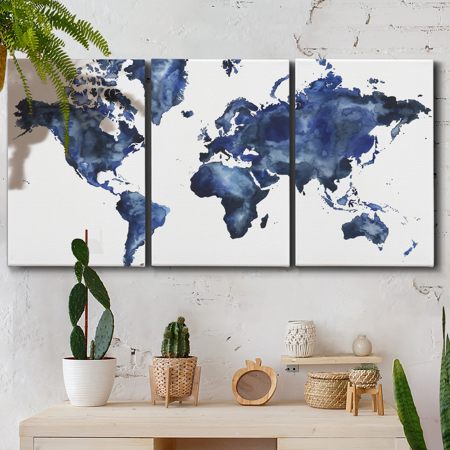 Three-panel canvas wall art featuring world map with water motif, displayed in a boho-chic entryway above a console table.