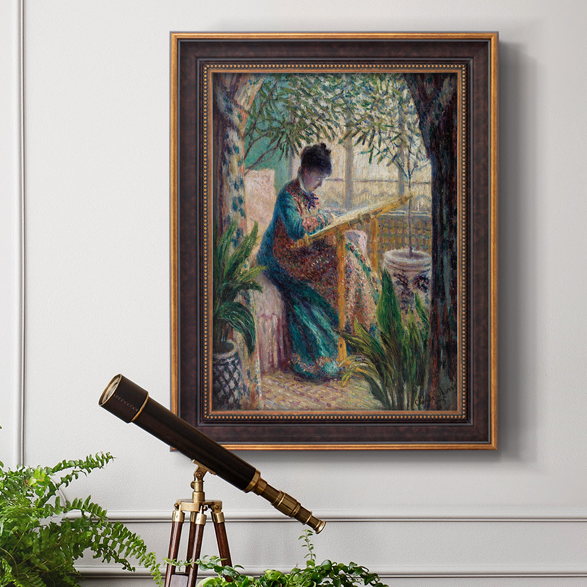 Impressionist portrait of Madame Monet sewing by Claude Monet in an ornate bronzed mahogany wood frame displayed in a light-toned interior setting.