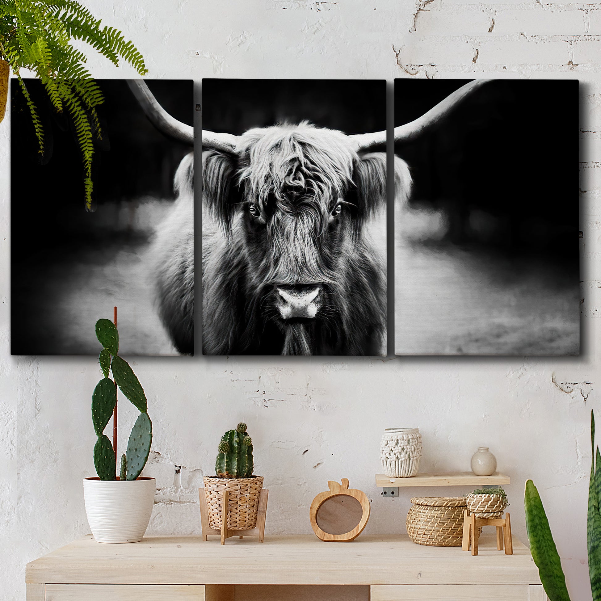 Three-panel canvas wall art featuring black and white cattle portrait, displayed in a boho-chic entryway above a console table.