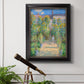 Impressionist garden landscape painting by Claude Monet in an ornate black frame with gilded inner detail displayed in a light-toned interior setting.