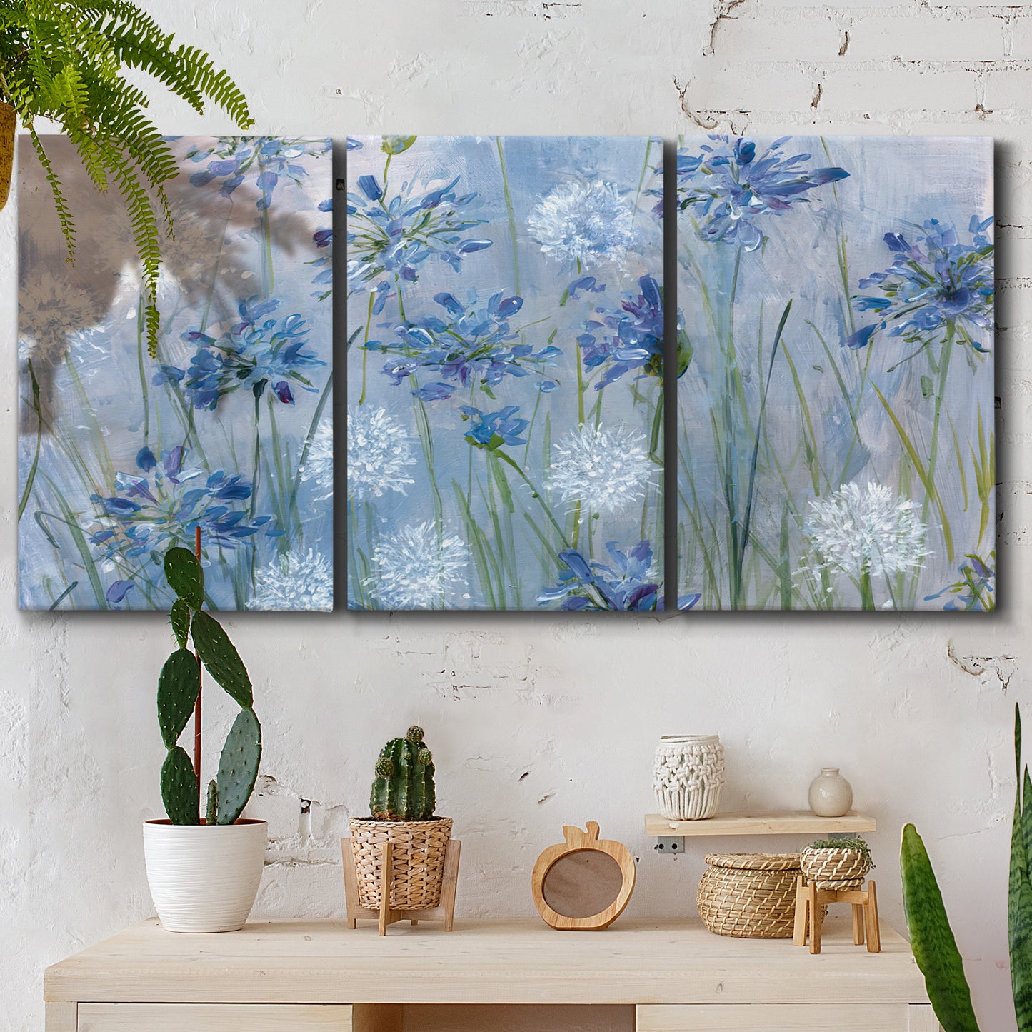 Three-panel canvas wall art featuring delicate watercolor floral blooms, displayed in a boho-chic entryway above a console table.
