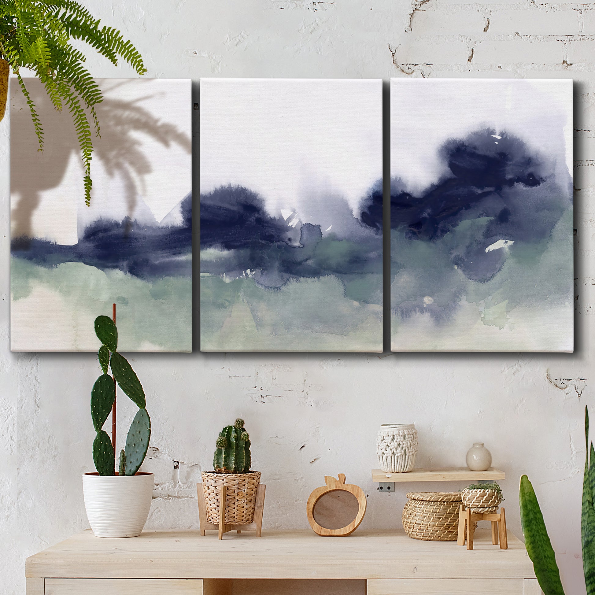 Three-panel canvas wall art featuring misty abstract lake watercolor, displayed in a boho-chic entryway above a console table.