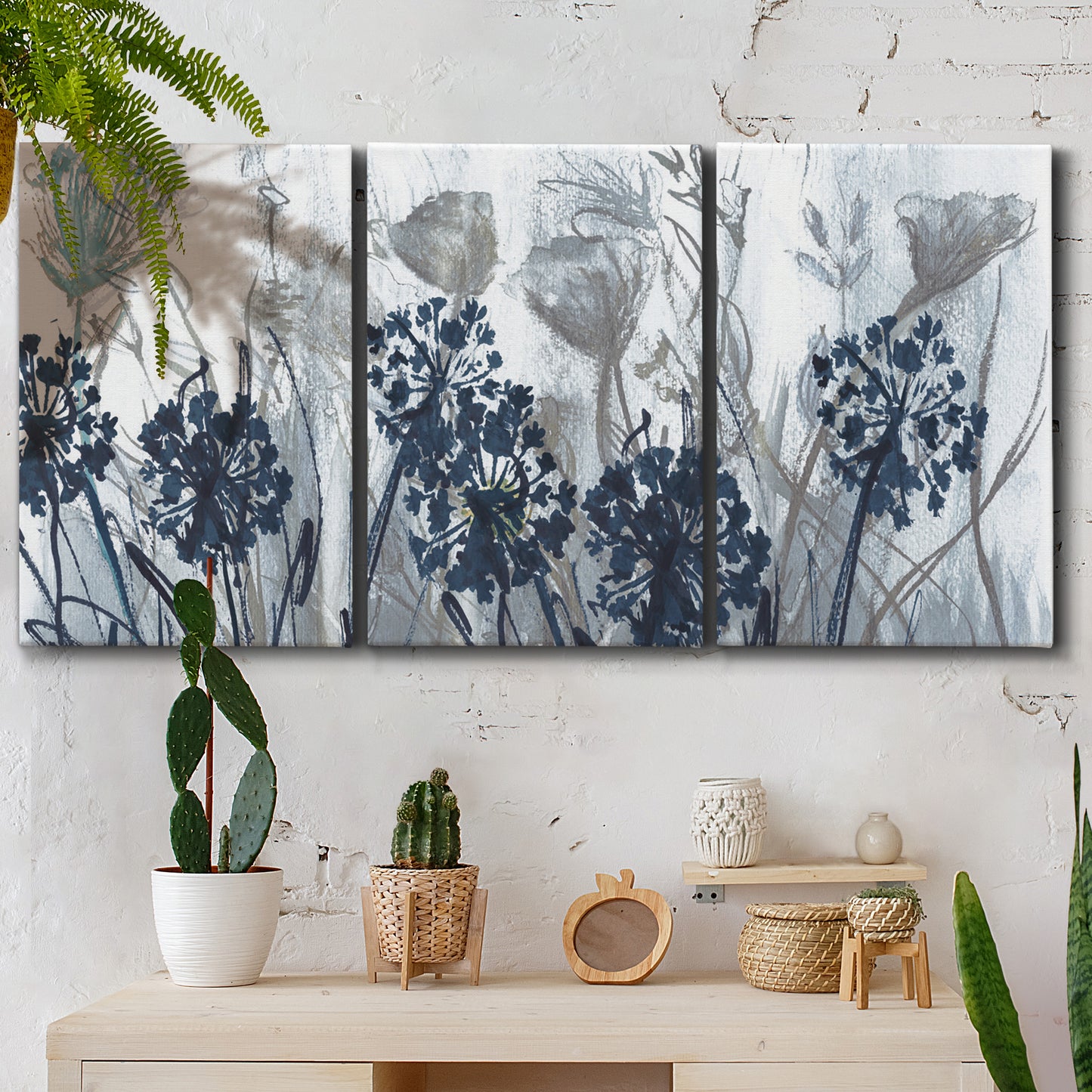 Three-panel canvas wall art featuring indigo floral abstraction, displayed in a boho-chic entryway above a console table.